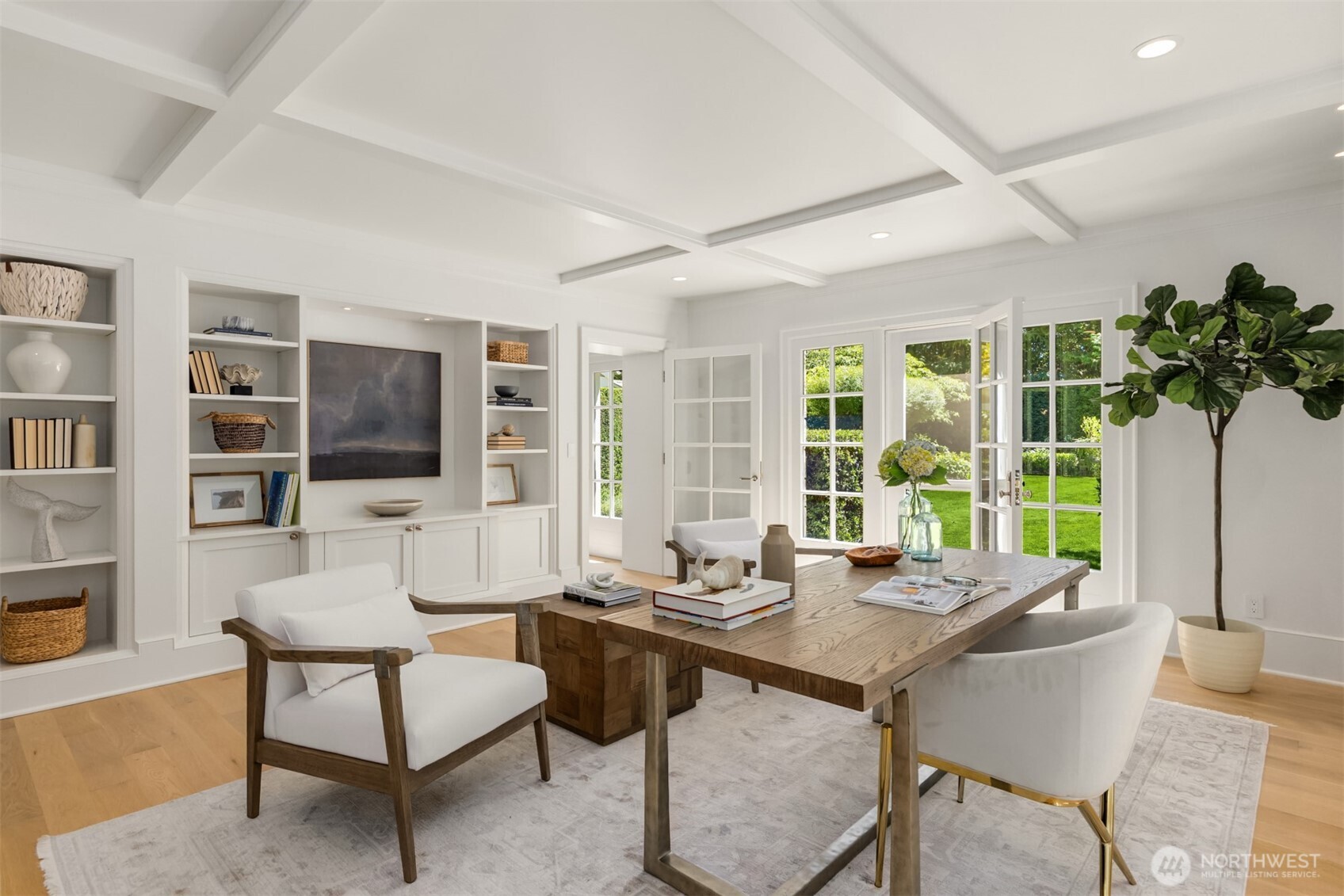 Refined home office featuring custom built-in shelving and French doors.