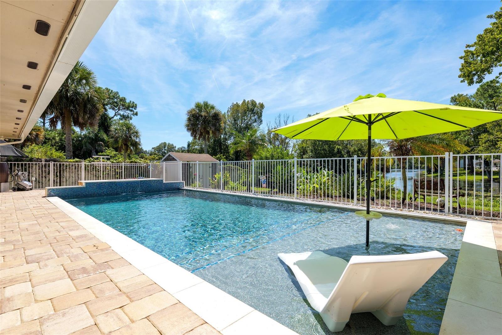 LAKEFRONT + RESORT-STYLE POOL + NO RENTAL RESTRICTIONS! Welcome to 76 Flamingo Drive, where everyday living feels like a Florida vacation. This spacious 3-bedroom, 3-full-bath home on Ribbon Lake offers the space, flexibility and outdoor lifestyle buyers are looking for—whether you're searching for a full-time home, second home or a standout short-term rental opportunity in Palm Coast.Inside, tile flooring throughout means NO CARPET, while plantation shutters add a polished Florida feel. The heart of the home is the spacious kitchen featuring shaker cabinetry, granite countertops, bar seating, stainless steel appliances approximately one year old, wall oven, wall microwave, glass cooktop and stainless steel range hood. The kitchen opens to the large family room and oversized sunroom—an incredible extension of the living space with direct access to the pool deck.With THREE full bathrooms, the layout is especially well suited for guests and vacation-rental use. One full bath is conveniently located off the sunroom and functions perfectly as a pool bath. A large laundry room provides additional storage, and the home also includes a 2-car garage. Additional features include a 2025 HVAC system and tankless water heater. Step outside and you'll understand what makes this property special. The approximately 15' x 37' saltwater pool is only 3 years old and was designed for a true resort experience with a pebble finish, natural stone coping, waterfall, FIRE FEATURE, LED lighting and lighted bubblers on the sun shelf—with room for in-pool loungers. Jandy pool equipment and a recently sealed paver pool deck complete the setup. Enjoy the screened lanai with sliding screen access to the pool area and a partially fenced backyard surrounded by lush, mature tropical landscaping.Beyond the pool is Ribbon Lake—fish for bass from your own backyard or launch a kayak and enjoy the water. The lake also supplies the home's irrigation system, helping reduce water usage for the extensive landscaping, which includes both drip and traditional irrigation. Banana trees, citrus trees and grapes add to the property's tropical Florida feel. A backyard shed is already wired for electric.Located in Flood Zone X with NO RENTAL RESTRICTIONS, this property offers an exciting opportunity for investors looking for a Palm Coast short-term rental with the amenities guests search for: a private resort-style pool, lakefront setting, multiple gathering spaces, 3 full baths and room to spread out.Live here, vacation here or let it work for you—76 Flamingo Drive delivers the Florida lifestyle inside and out.