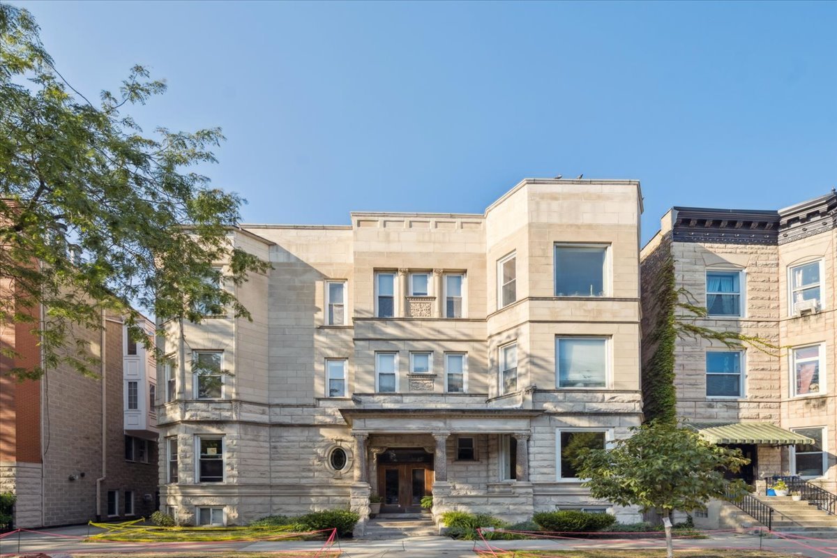 Set on the second floor of a classic three-story, six-unit greystone on a quiet one-way street, this 2 bed/2 bath home pairs historic character with smart functionality. The bright living room showcases high ceilings, oak floors, and a wood-burning fireplace; an octagonal turret alcove with windows flexes as a dining area, office nook, or reading spot, while a separate hallway cove near the kitchen/bedrooms offers a second option for dining or a desk.    The kitchen features granite counters, stainless steel appliances, a glass tile backsplash, and ample cabinetry. Bedrooms are generously sized with custom storage, including a large walk-in closet in the primary. Two full baths include one with a walk-in shower and double vanity, and another with a tub/shower combo.    A large private deck with leafy views extends the living space; in-unit laundry, storage off the deck, and a deeded parking space behind the building add everyday convenience. Close to Broadway, Halsted, and Belmont, and just one block from Belmont Harbor with easy access to the lakefront and Lakeshore Path.
