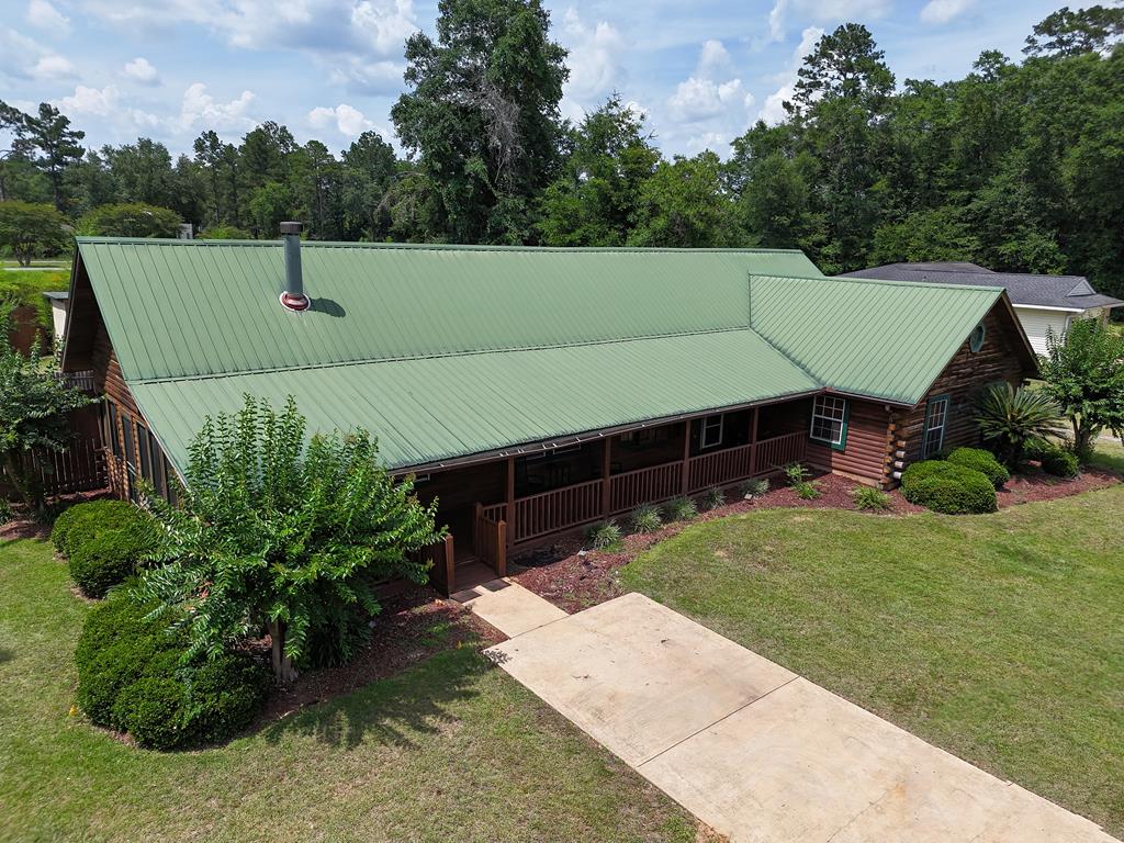 Take a look at this WONDERFULLY RUSTIC home in the heart of Bainbridge, GA! This 4BR/2Bath home combines the timeless charm of a log cabin with the elegance of modern design. Inside, you will find a great open living room and dining room, BEAUTIFULLY modern kitchen, and home office that opens out onto your very own backyard oasis. The primary suite is huge with a custom stone fireplace, built in shelves and attractive wood flooring. The attached bathroom features luxury shower, double sinks, and a big dressing room that connects to the nice laundry room – convenience at its best! Another large bedroom at the opposite end of the house can also be used as a separate den or entertainment room, and there are an additional 2 bedrooms and bathrooms as well. Outside is where the party's at, with a nice in-ground pool and 2 ENORMOUS covered decks – perfect for grilling and chilling! At the front of the house you will also enjoy the big rocking chair front porch and screened patio, with fans! Call your favorite agent TODAY for a closer look at this wonderful property! Click here for virtual tour: https://my.matterport.com/show/?m=LfiLb7rqPjM&mls=1