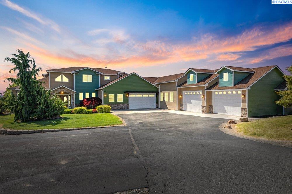 MLS# 292895 Experience the perfect blend of luxury, space, and recreation on this stunning custom-built estate situated on 2.26 private acres with sweeping territorial and mountain views. Offering 5,799 total square feet, including 3,729 square feet of thoughtfully designed living space, this home features 4 bedrooms, 3 bathrooms, a dedicated office, expansive entertaining areas, and an additional 2,000 square feet of partially finished basement space with framing already in place for easy window installation—ideal for additional bedrooms, a theater room, gym, guest quarters, or multi-generational living. From the moment you enter, you’re welcomed by soaring ceilings, a grand staircase with custom iron railing, and quality finishes throughout. The spacious living room features tray ceilings, large windows capturing the surrounding views, and a stunning stone fireplace centerpiece. The kitchen was designed for gathering, featuring abundant cabinetry, a center island, custom lighting, and seamless flow into the dining and living spaces. A separate game room with full bar creates the perfect setup for entertaining. The outdoor amenities are just as exceptional. Enjoy the expansive Trex deck complete with a built-in BBQ kitchen, pergola-covered seating areas, and hot tub, all positioned to take in the peaceful surroundings and unforgettable sunsets. Just below the deck, a custom built-in fire pit with surrounding seating creates the perfect space to relax and entertain. The fully fenced sports court adds another level of recreation rarely found in residential properties. Car enthusiasts, hobbyists, or anyone needing substantial workspace will appreciate the massive attached shop featuring three oversized bays connected to the attached 2-car garage, offering exceptional room for vehicles, boats, RVs, toys, storage, or projects. The property also includes extensive RV parking and wide open usable space. This is a rare opportunity to own a one-of-a-kind property that combines upscale living, recreation, shop space, and privacy, all in an incredible setting.