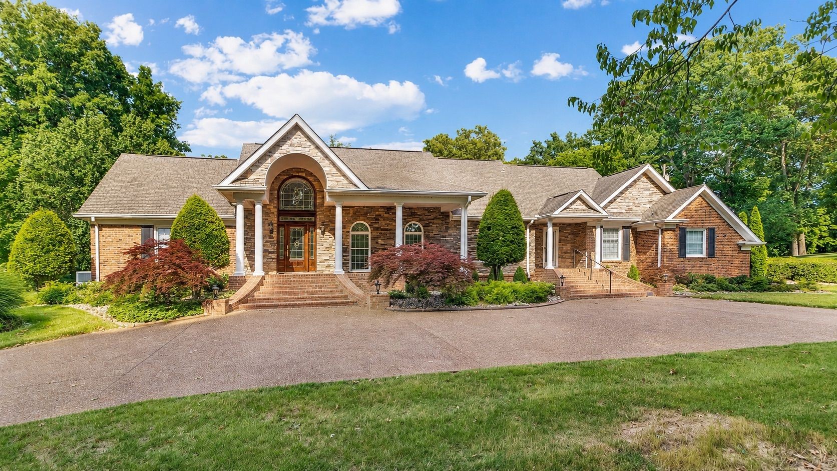 Welcome to one of Clarksville’s premier luxury estate properties in the prestigious Belle Meade subdivision! This spectacular brick custom home offers 5,551 square feet with 5 bed, 4 baths, and 2 half baths on a beautifully landscaped 1.48-acre bluff lot. Perfectly positioned on a quiet cul-de-sac, this remarkable property enjoys breathtaking views of the Red River and the River Club Golf Course from the rear while sitting directly across the street from the Clarksville Country Club. A grand aggregate circular driveway welcomes guests to an impressive front entrance featuring a soaring foyer. Inside you’ll find elegant formal living and dining rooms with a fireplace, an expansive great room with vaulted ceilings and fireplace, a cozy den with fireplace, a stunning sunroom with fireplace, and a chef-inspired kitchen designed for entertaining and everyday living. The thoughtfully designed split-bedroom floor plan offers three bedrooms on the main level, including an exceptional primary suite featuring heated tile floors in the luxurious bath. Upstairs are 2 beds with Jack-and-Jill bath. Car enthusiasts and hobbyists will love the heated and cooled 5-car garage complete with its own full bath and kitchenette, creating the perfect private retreat or ultimate workshop. A whole-home Generac generator provides added peace of mind. Outdoor living is equally impressive with a spacious rear patio overlooking the river, plus a second patio nestled along the wooded bluff offering even more dramatic panoramic views. The home also features a secondary entrance providing direct access to the kitchen, ideal for catering, groceries, or everyday convenience. This is a rare opportunity to own one of Clarksville’s finest luxury homes, combining timeless elegance, unmatched craftsmanship, spectacular views, and an exceptional location. Be sure to view all photos, drone photography, videos, and additional media to fully appreciate everything this extraordinary property has to offer.