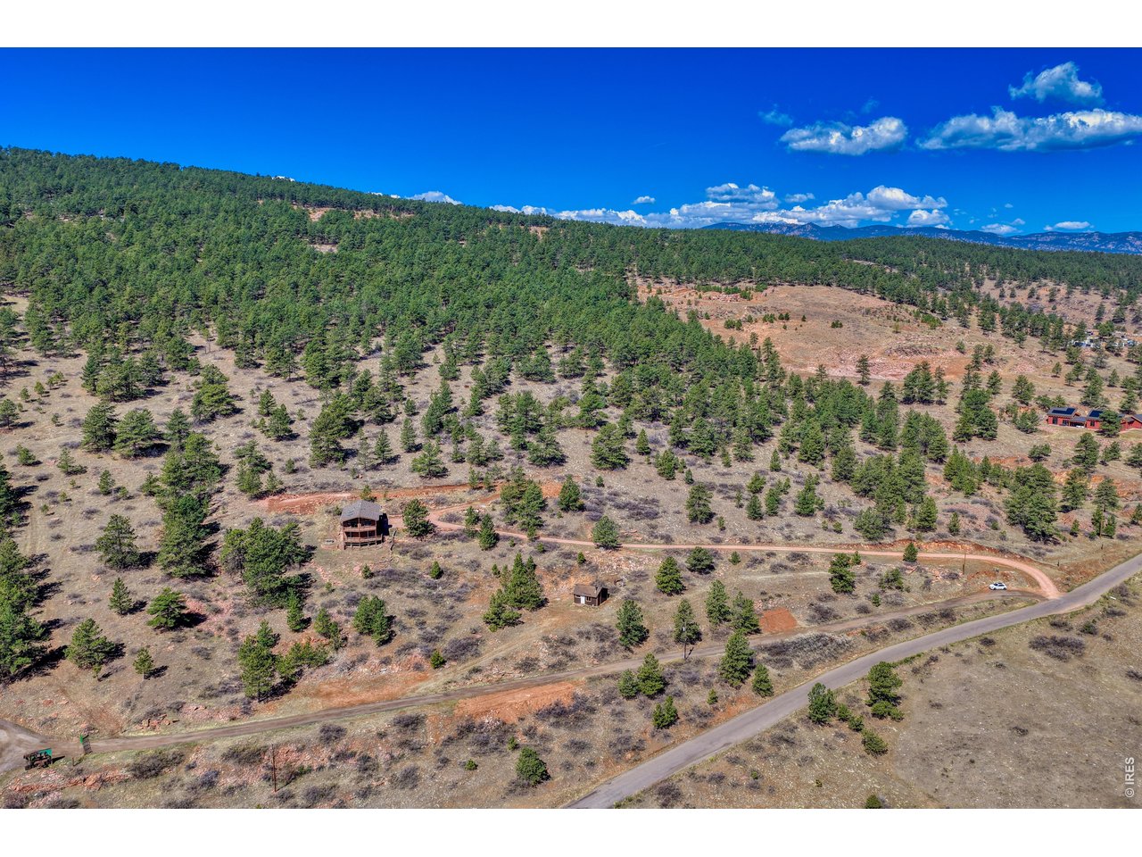 Incredible value for this MOVE-IN ready custom home and property in Lyons! There's plenty of room to roam on 34 private acres with mature evergreens, striking red rock formations, and awe-inspiring dark night skies. The light-filled floor plan boasts gorgeous VIEWS from every window, multiple indoor and outdoor living spaces, generous storage, and a separate outbuilding. The updated kitchen includes Lyons sandstone countertops, soft-close cabinets with pullout drawers, under-cabinet lighting, ample storage, a dual fuel range/oven, and tile flooring. Newer hardwood floors in the living and dining areas, new carpet in the three bedrooms and family room, and a pellet stove add comfort and warmth throughout. Additional features include a primary suite with a private bath and walk-in closet, a spacious laundry room, and a huge walk-in unfinished basement/Flex space providing easy access to mechanical systems and extensive storage. Access is easy, no steep roads. Just 3-miles from Hwy 36, this sweet mountain property offers quick access to Lyons' restaurants, schools, parks, trails, river, and festivals, as well as Boulder, Longmont, Denver, DIA, and Rocky Mountain National Park. NOTE: The property has a Longmont mailing address in the 80503 zip code, but Stone Canyon is part of the Lyons community. Schedule your personal tour today.