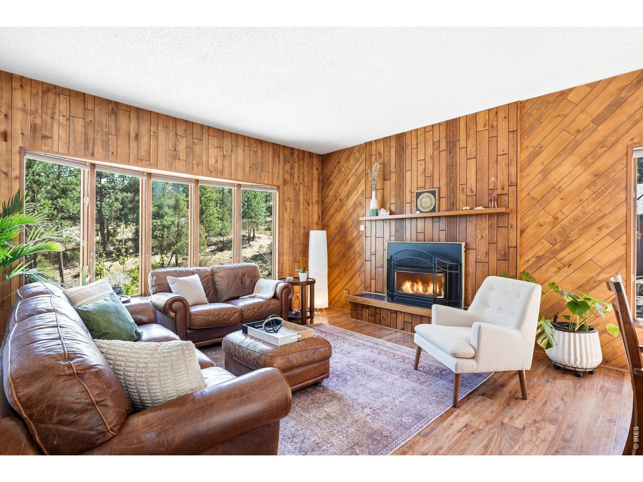 Tucked into the pines on 2.5 private acres, this inviting Pinewood Springs mountain retreat captures the best of Colorado living. With a level, easy-access driveway, natural landscaping and fresh mountain air this property reflects true pride of ownership in a setting that feels peaceful, private, and deeply connected to nature. Flagstone steps lead to a warm interior with hardwood floors and fabulous windows that bring the outdoors in. The open kitchen is truly the heart of the home with a welcoming counter space, bar seating, and easy flow into the dining area and main living room, perfect for gathering around the fireplace. There's a space for everyone with a 2nd living room, flex space and 2 main level BR's plus laundry room. Upstairs, 2 flex rooms perfect for office or guests plus the primary BR features a private deck overlooking the mountains- ideal for morning coffee or evening reflection. Outside, the lifestyle continues with a patio for BBQs and fire pit gatherings. The oversized detached garage w/workbench & storage handles all your gear and level lot offers plenty of room to park RV, boats, snowmobiles & more. Adventure begins right outside your door, with rock outcroppings and slabs for bouldering in the backyard and just steps to a trailhead with miles of trails for hiking, biking, and exploring. A seasonal stream draws deer, elk, and wild turkeys that wander through the acreage, adding to the everyday magic of mountain life. Pinewood Springs is more than a neighborhood-it's a warm mountain community where neighbors wave, walk the roads, gather for driveway happy hours, and truly show up for one another. Residents also enjoy access to The Tubs, a beloved local rock canyon swimming hole. Enjoy peace of mind with a new roof (2022) and a brand new septic system (2026). A private retreat in the heart of the Rockies, offering the perfect balance of peace, adventure and easy access to Estes Park, Lyons, and Boulder. Welcome Home.