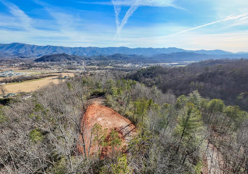 Panoramic views of the beautiful Appalachian Mountains and the quaint city of Andrews NC on a lot that's ready to build! This 2.06-acre lot offers a unique chance to build your dream home with stunning natural beauty. Overlooking Andrews, NC, enjoy breathtaking views of Nantahala National Forest, mountain ridges, and the valley below. Wake to mist-shrouded peaks and vibrant sunsets – ideal for nature lovers seeking tranquility. Primed for construction: Well-maintained gravel driveway leads to a cleared, level building site. Septic installed for 2-bedroom home, compliant with regulations. Well permits secured; owners' deposit on drilling waitlist. Electricity available below, ready to extend. This turnkey setup saves time and money, letting you focus on your vision. Accessibility shines: Live Oak Terrace paved most of the way, with sturdy gravel to property; for year-round access. Just 5 minutes from downtown Andrews for shops, dining, schools, and events, yet private and secluded. Outdoor enthusiasts thrive here: Short drive to Nantahala River for whitewater rafting/kayaking. Endless hiking trails to waterfalls in Nantahala or Joyce Kilmer Forests. Trout fishing in mountain streams; scenic cycling routes. 15 minutes to Harrah's Cherokee Valley River Casino for gaming/entertainment. Hour + to Asheville for airports, culture, and amenities, preserving mountain peace. Andrews is a charming town with history, friendly vibes, and appeal for retirees, families, remote workers. Surrounded by 500,000+ acres of wilderness, enjoy four seasons: spring blooms, summer greenery, fall foliage, winter snow. Abundant wildlife like deer, turkey, bears enhances the Appalachian feel. Lot's elevation maximizes views and privacy for cabin, retreat, or estate. Priced competitively in booming Western NC market – exceptional value where adventure meets serenity. Schedule a viewing today!