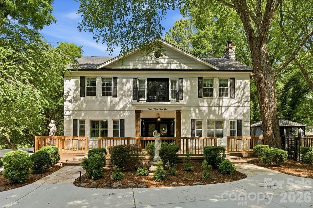 Located in the heart of SouthPark, this beautifully updated 1920's residence offers a rare opportunity to own a piece of Charlotte’s history—thoughtfully reimagined for modern living. Set on a private half-acre lot, the home blends timeless architecture, refined updates, and a lifestyle that’s hard to replicate this close to the city. You'll be impressed the moment you step through the front door from the grand entry foyer with a sweeping staircase and soaring ceilings, to the natural light and character that carry through every room. The kitchen has been fully reimagined with new cabinetry, quartz countertops, and an oversized island that connects naturally to the main living areas. You will also find one of the home’s most compelling features on the main level: an additional suite, complete with a separate entrance, second fully remodeled kitchen with quartz countertops and custom hall tree, and attached bedroom. Whether it serves extended family, long-term guests, or a more tailored use of space, the flexibility it offers is endless. Upstairs, the primary suite includes a fully renovated bathroom with a soaking tub and custom closet built-ins, and a bookshelf-lined loft opening to a charming balcony right outside the door— making it an ideal reading nook, workspace, or play area. With 4 bedrooms, 3.5 bathrooms, a dedicated office, and an additional finished attic and basement —including a hidden wine vault— this home truly provides the space and flexibility to grow into over time. Outside, you’ll find two separate driveways for parking, a large porch, and the fully fenced half-acre delivers privacy that's difficult to find. A putting green and expansive lawn provide room to entertain, relax, or expand— with ample space to add a future pool. With walkability to Strawberry Hill shopping and dining, close proximity to SouthPark, and access to highly-rated private + public schools, it’s increasingly rare to find a home like this in a location that places you at the center of it all.