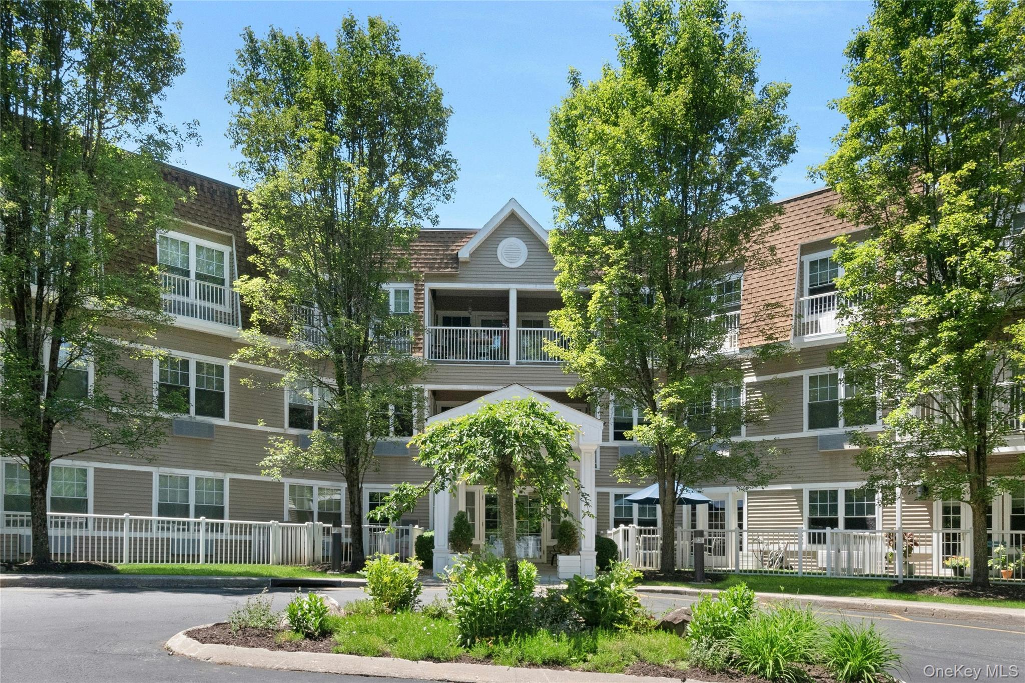 Welcome home to this turn key top floor 2-bedroom, 2-bath end unit condo, nestled in the vibrant 55+ community of Sutton Manor (One resident must be 55). The open layout features sunny tree-top views, freshly painted interiors, new white oak flooring, updated baths and designer finishes throughout. Enjoy easy meal prep in the elevated chefs kitchen with new LG stainless steel appliances and open breakfast bar that transitions seamlessly into the living/dining spaces for effortless gatherings and entertaining. Unwind in the spacious primary bedroom featuring a generous walk in closet, ensuite bath and a cozy window nook. The second bedroom with adjacent bath can easily accommodate guests or serve as a home office. The new multi function washer and dryer further enhances the comfort and convenience of this special offering. Residents of the building enjoy direct elevator access to their indoor garage space, and use of the community room that features a full kitchen, dining and living room areas, and a separate fitness room. Heat, hot water, water, snow removal, and trash are included in the association fees, while the building is equipped with a back-up generator. Ideally located near Metro North, shopping, restaurants, medical facilities and a multitude of recreational opportunities render this an opportunity not to be missed!