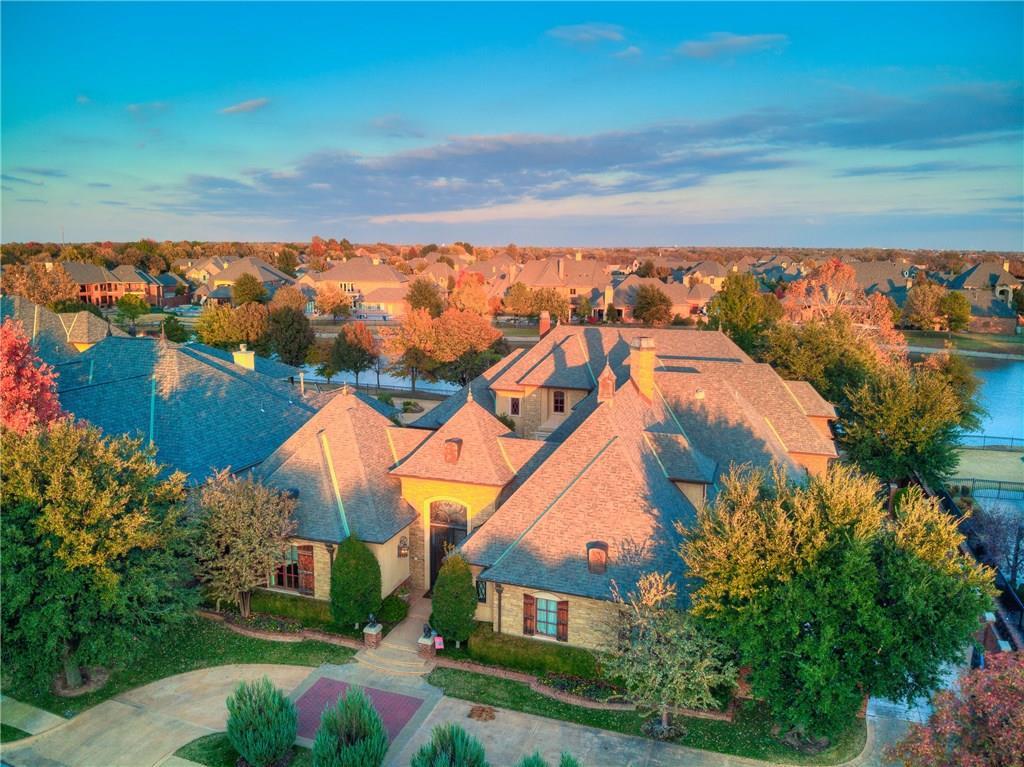 One-of-a-kind European-style home with lake views in one of Oklahoma City’s most desirable neighborhoods.This true entertainer’s residence delivers rare scale and refinement. The chef’s kitchen features a commercial gas range, three dishwashers, dual sinks, warming drawer, instant hot/cold water, a massive island that seats six, and a huge pantry—all open to an expansive living room with a stone fireplace.The formal living room impresses with a two-story cast-stone fireplace, built-ins, and floor-to-ceiling windows framing the lake. Natural light pours through the home.The primary suite faces the water and includes a private sitting room with fireplace, dual walk-in closets, and separate vanities and toilets. Four bedrooms sit under the main roof, plus a versatile casita by the pool complete with full bath, kitchenette, and walk-in closet.Additional highlights include an elevator, two staircases, theater/game room, exercise room with three-wall mirrors, home office with extensive built-ins, multi-purpose play/computer room, two laundry rooms, aboveground safe room, and walk-in attic.Outside, a courtyard pool is surrounded by lush landscaping and an outdoor kitchen. A second patio with cast-stone columns and gas fireplace faces the lake, with a balcony above overlooking the water.The oversized four-car garage offers stained etched concrete, dual mini-splits, a large sink, abundant built-in cabinetry, and space for extra refrigeration and storage. Energy-efficient geothermal system and blown insulation complete the package.Exceptional indoor-outdoor living with lake views