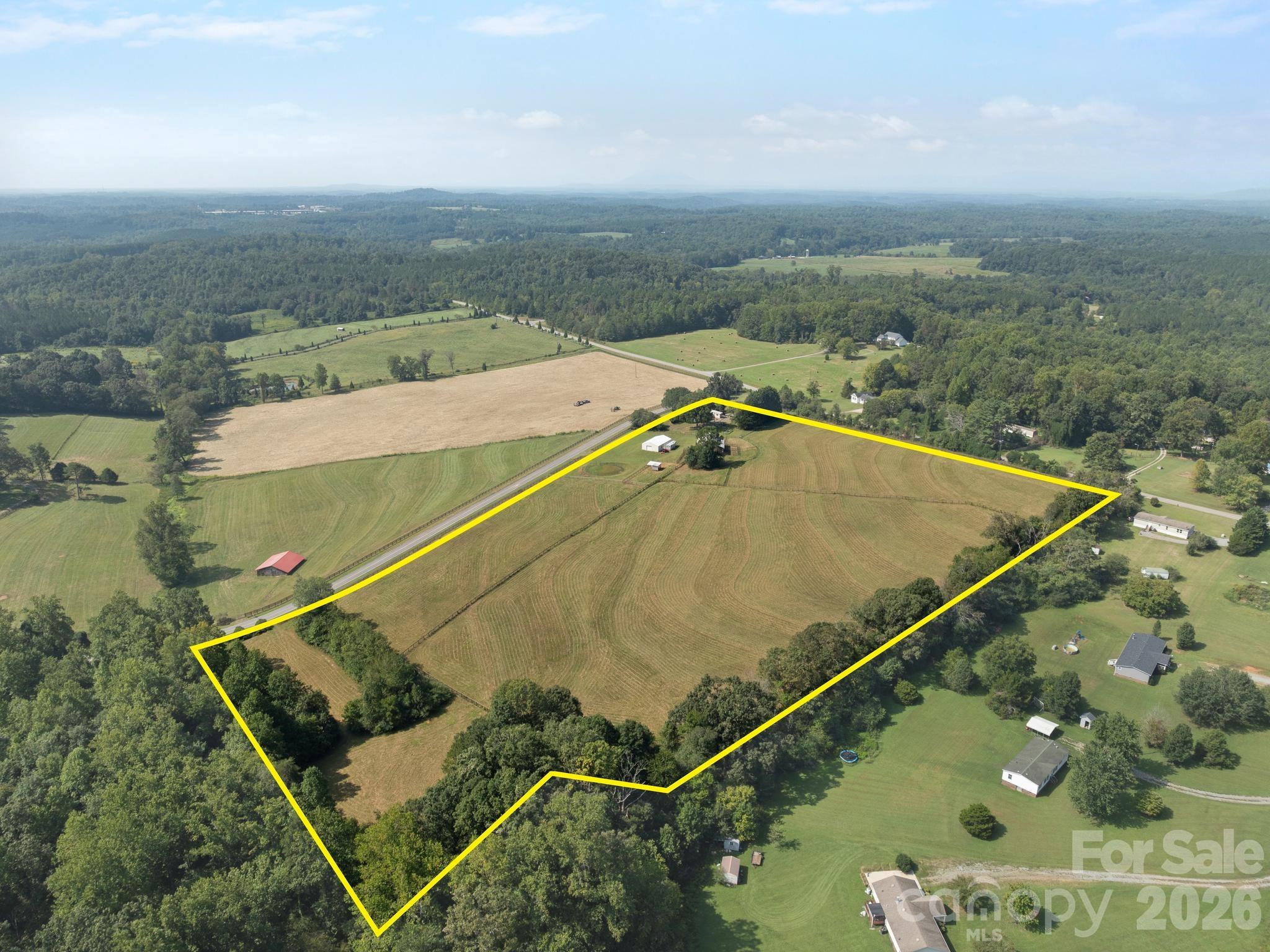 $30k Price Reduction - Dreaming of a farmhouse with a rocking chair front porch and all the charm of yesteryears but with an open floor plan, large rooms and wonderful updates? Looking for a peaceful setting with a well-planned, move-in ready setup to accommodate your horses and other farm animals? This estate has it all! With 19 acres of pasture, most of it fenced, a spacious center aisle barn with loft plus a huge, insulated workshop/garage building with electricity and an RV hook-up, you have everything you need. Frost free water spickets in every field; a run-in shed in addition to the barn, a round pen and a chicken coop. Remote controlled gated driveway and large fenced yard for dogs.Updates to the house include addition of a deck, carport and inground pool in 2022; in 2026- gutters replaced, new well pump and new water heater including all new conduit and electric to the well pump; 2 HVAC units (one for each level) installed 2014 are serviced 2x a year; vapor barrier in crawlspace with sump pump; upgraded windows, metal roof installed 2012 was professionally cleaned this year and everything was pressure washed- house, deck, carport. The septic system was pumped a few months ago. The heart of the home is a spacious Great Room, anchored by a kitchen with premium cabinetry and a central cooking island surrounded by open dining space and a cozy fireside seating area. A separate traditional dining room and an inviting living room offer additional spaces to gather. At the back entrance, a massive mudroom/laundry room provides abundant storage and the perfect drop-zone after a day on the farm. Also, a washer and dryer on the upper level. On a hot day, you'll enjoy the luxury of your own easy care saltwater pool. Whether sitting by the pool or on the front porch, you will be lulled by the peaceful views of open land, mature shade trees and a flowering landscape. Only 10 minutes to restaurants and stores in downtown Rutherfordton and 25 minutes to Tryon International Equestrian Center. If you own a plane, you'll love having Rutherford County Airport close by. This property is a rare find where you have conveniences nearby while feeling a world away on your own farm paradise.