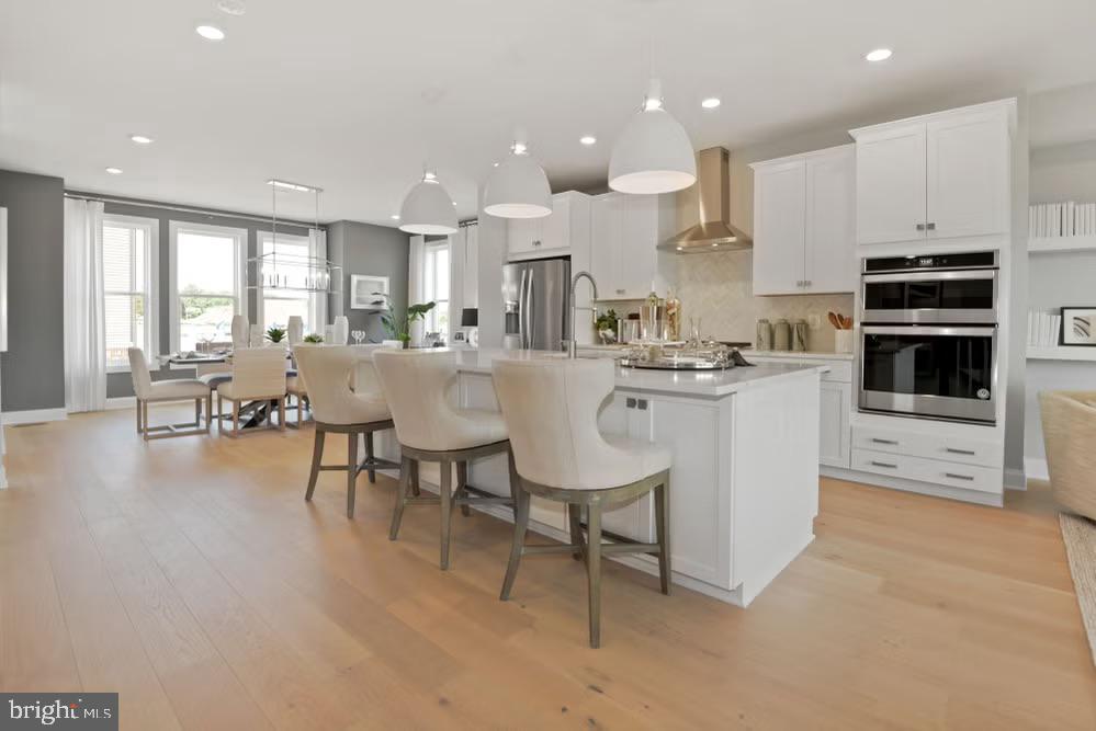 (Homesite 77) *Photos of a model home* Under construction, +/- December delivery. Location-location-location! Easy access to the Reston Town Center and Metro Stations just steps from the W&OD Trail. This stunning townhome features 4 finished levels, 3 Bedrooms, 3 full baths and 2 half baths. The entry level has a private guest suite with attached full bath, perfect for in-laws or office. Main level has soaring 10' ceilings, floor to ceiling cabinetry, coffee bar, fireplace, and oversized casement windows drenched in sunlight. The Primary suite boasts a huge walk-in closet and a luxurious en-suite bath with private water closet. Enjoy sunsets on the rooftop terrace overlooking the pond and beautiful mature trees. Loft space perfect for work or entertaining