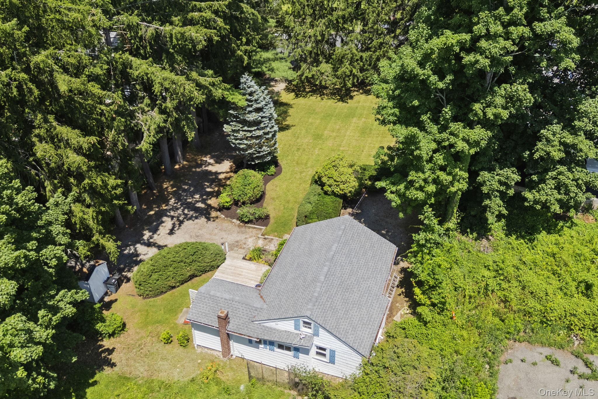 Opportunities like this do not come around often in Chappaqua, and when they do, they tend to move quickly. What is being offered at 58 Maple Ave is a flat, level, in-town parcel with an existing 2-bedroom, 1-bath cottage set back from the road among towering pines, in one of Westchester County's most coveted villages. Whether a buyer chooses to develop the land, renovate what is there, or simply occupy the existing structure while planning next steps, the opportunity here is defined first and foremost by the location and the lot.The cottage itself, built in 1930 and totaling 711 square feet, is being sold strictly as-is. It sits on a 0.28-acre lot with driveway parking and includes a front deck, a patio, and a yard with a quiet, private feel that genuinely surprises you given how close you are to the center of town. Inside, the main level includes a great room with cathedral ceilings and built-in features, a kitchen, two bedrooms, and a full bath. A partial basement with Bilco door access houses laundry and mechanicals. The structure has a history as a consistently rentable asset in a market where rental demand is strong and vacancy is rare, which speaks to the enduring appeal of this particular address regardless of what a future owner ultimately decides to do with it.The location is the defining feature and the reason this property commands the attention it does. You are minutes on foot from the Chappaqua Metro-North Station, putting Midtown Manhattan within comfortable commuting distance without the stress of a car or a parking lot. The village's boutique shops, restaurants, and parks are equally walkable, giving this address an everyday livability that most Westchester properties simply cannot replicate. For those who travel frequently for business, Westchester County Airport is also easily accessible. This is a genuinely rare convergence of walkability, transit access, and village character that defines the upper end of what Chappaqua real estate has to offer.The property falls within the Chappaqua Central School District, one of the most highly regarded public school systems in New York State and a consistent driver of demand in this market.Flat lot, set-back privacy, walk-to-train location, and Chappaqua schools.