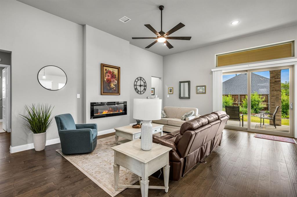 This beautifully designed Allure floorplan blends elegance and comfort with soaring 12-foot ceilings, abundant natural light, and a fresh, neutral palette. The open great room features a striking fireplace and sliding glass doors that lead to an extended patio and a private, resort-style backyard perfect for entertaining or quiet relaxation. The chef-inspired kitchen impresses with quartz counter tops, stainless-steel appliances, double ovens, a walk-in pantry, and a spacious island. The luxurious owner’s suite offers a vaulted ceiling, sitting area, and spa-style bath with an oversized walk-in shower. A convenient half bath and several deep storage closets, including three oversized hallway closets, add thoughtful functionality. The primary closet’s soaring ceiling accommodates a third hanging rod for extra storage. With its preferred location, bright open design, and meticulously landscaped backyard, this one-of-a-kind home offers the perfect blend of sophistication, style, and livability.