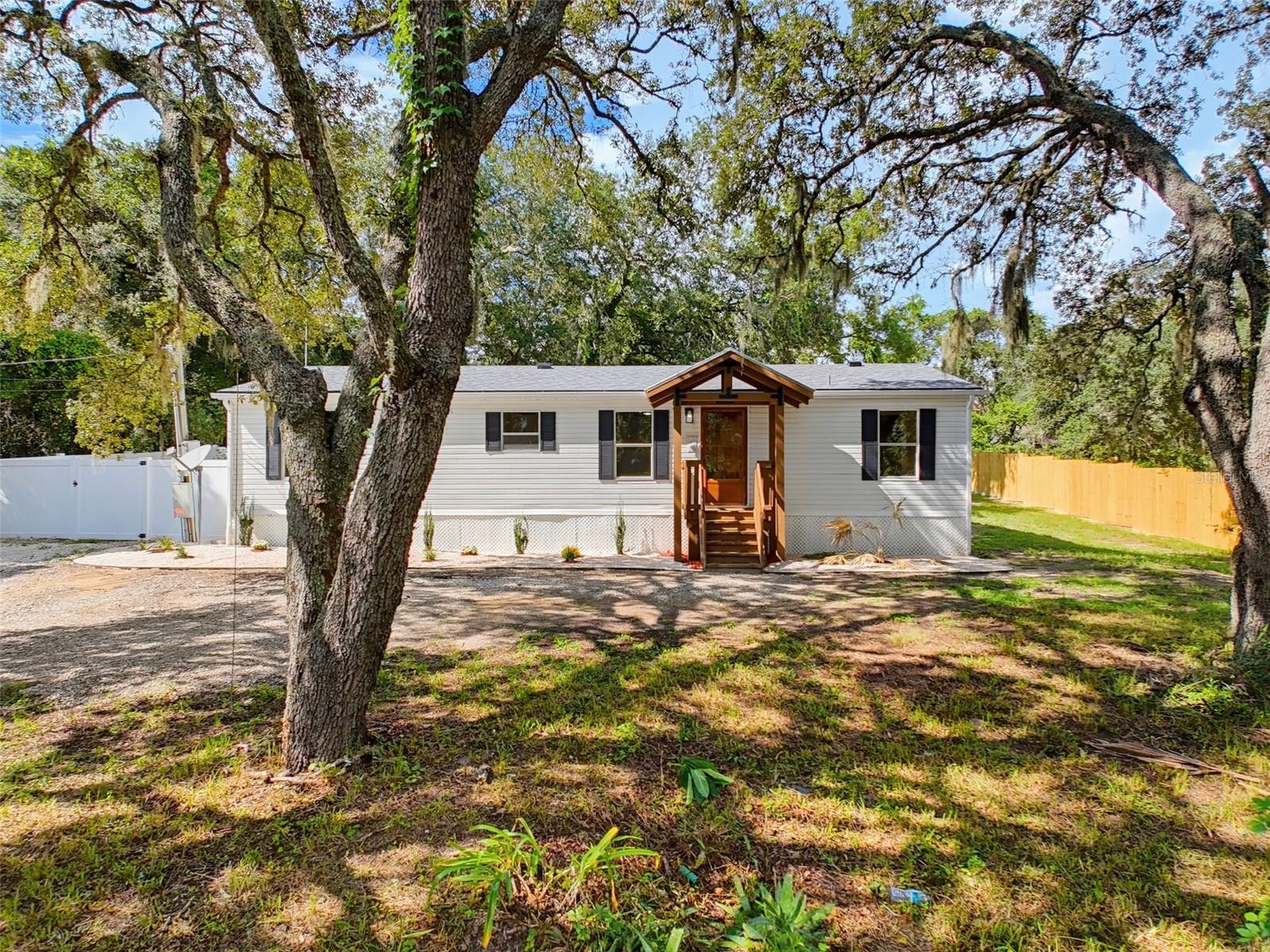 Country living! This turnkey, fully remodeled 3-bedroom, 2-bathroom home sits on an impressive peaceful .45-acre lot. BRAND-NEW BIG-TICKET ITEMS include a NEW ROOF, NEW WATER TREATMENT SYSTEM, and NEW HOT WATER HEATER. Interior highlights include BRAND NEW bathrooms with spa-inspired showers, NEW luxury vinyl plank flooring throughout, granite countertops, stainless steel appliances, new contemporary fixtures, fresh interior paint, and an open floor plan with abundant natural light.The property also features a private well and septic system, reducing monthly utility costs, plus a large lockable storage shed. With no HOA and low property taxes, this home offers added flexibility and huge affordability benefits.The owner is completing the legal conversion from personal property to real property, commonly known as “detitling” or retiring the mobile-home title. Once completed/recorded, the home will be permanently affixed to the land and treated as real property. This allows more financing options/potential financing through FHA, VA, conventional, or other loan programs, subject to lender approval.Agricultural zoning provides room for a homestead-inspired lifestyle, including chickens and other permitted livestock, as well as parking for an RV, boat, or work vehicle. The spacious lot may also offer future potential for a detached garage, workshop, or ADU.Enjoy privacy and room to grow while remaining conveniently located near well rated schools, shopping, dining, medical facilities, major highways, and Gulf Coast beaches. Whether you’re seeking a full-time residence, winter retreat, or property with space for future plans, this home offers comfort, flexibility, and opportunity.