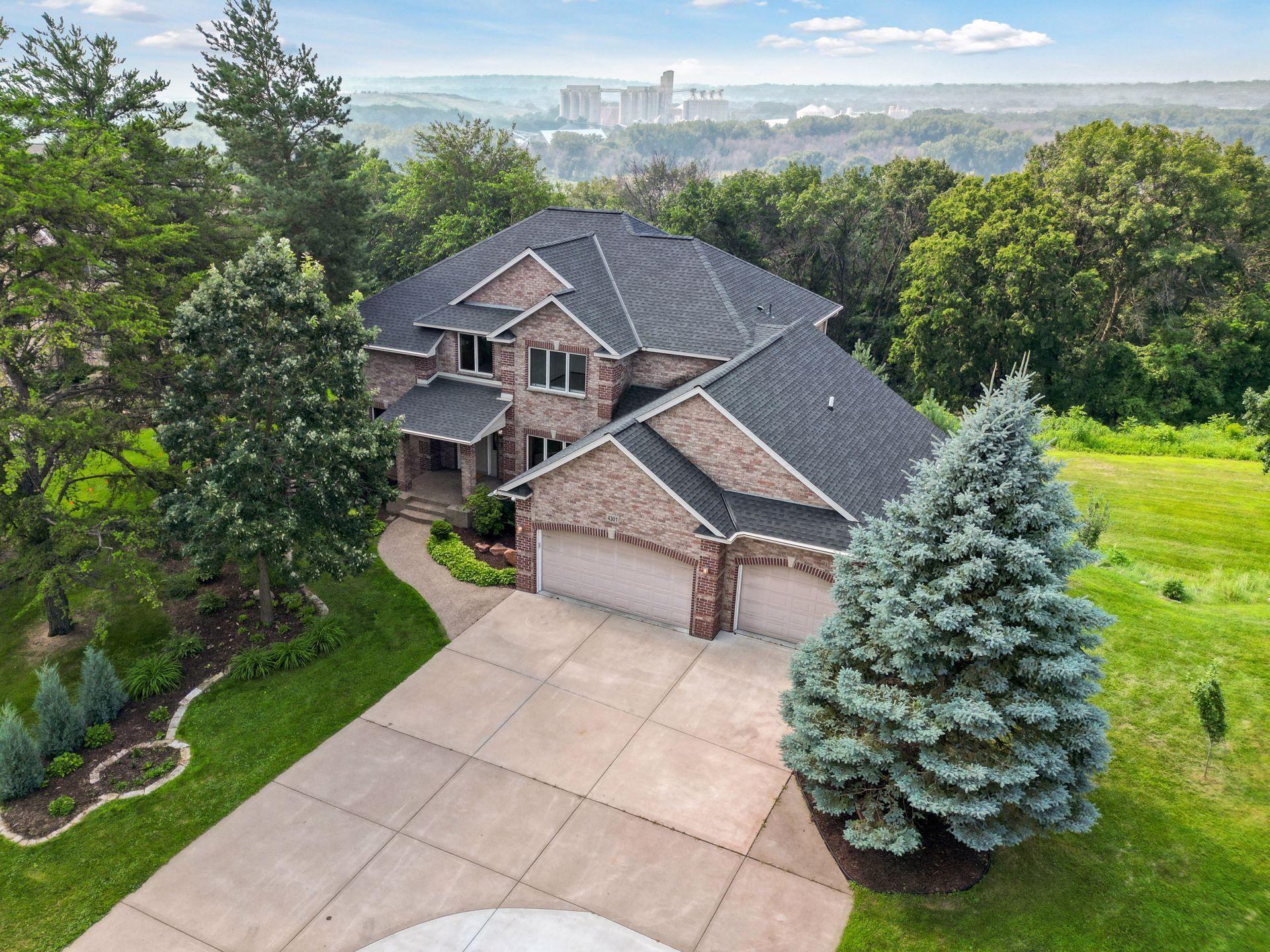 Space, privacy, and natural beauty—without leaving the city behind. This stately one-of-a-kind, custom-built home sits on 3.5 lush, wooded acres perched above the majestic Minnesota River Valley, offering stunning views, sunsets, and total serenity just 20 minutes from downtown Minneapolis. Built in 2001 and recently updated with many new improvements, the home offers an estate-like feel with understated elegance and timeless charm. It features large rooms, high ceilings, and an abundance of natural light and views through walls of oversized, south-facing windows. Inside, watch the oasis of wildlife as the birds fly high and mature trees of the sanctuary blow against the sky. The floorplan is great—efficient, yet flowing, spacious and flexible. The light and bright kitchen is recently updated with gorgeous quartz countertops, a modern backsplash, and new appliances to compliment the Wolf cooktop. The large primary ensuite is fully remodeled with a spa-like Jacuzzi tub, spacious waterfall shower, dual vanity and enormous walk-in closet. The size of the suite and treetop, atmospheric views in the summer and expansive river valley views in the winter make it uniquely special. Cozy up to the dual-sided gas fireplace—there is one on each floor. All bedrooms and laundry are conveniently located on one level. Enjoy peaceful mornings on the sunny deck, unwind in the elevated 3-season porch, or wander the Zen gardens and acreage that is your secluded retreat—or canvas. It’s a huge lot that gives you options—to expand, split, or simply enjoy the abundance of natural space. The backyard is newly fenced, landscaped, and has a freshly poured concrete patio to enjoy the sunshine and beauty with friends and family. This property is truly a private retreat and one of its kind.