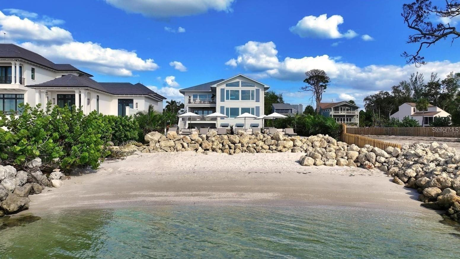 Experience private beachfront coastal luxury at this one-of-one Siesta Key home, thoughtfully curated for comfort, style, and entertainment - by Pham Development. Perfectly positioned off the Gulf, with gorgeous ocean views throughout the rooms - you can watch a world-class sunset view from your master bedroom. Spanning over 6,468 square feet under air and 9,080 total square feet, this exquisite residence captures the essence of resort-style waterfront living on more than half an acre of pristine Gulf-front land. Be at ease with a surrounding elevated riprap shoreline and the imported rocks, offering both protection and privacy.Pull into the property through the gated entry, with a paved driveway for ample parking. The ground level offers a 3-car garage, spacious private fitness studio with AC, large flex space/storage room, and huge game room that leads out to the truly special backyard - with premium turf, silica sand and a putting area. Host a sunset dinner with the full outdoor kitchen, including a freezer, wet bar, beverage center, ice machine, and 6-burner grill. Have a drink while sitting in the pool facing the ocean, relax in the champagne spa hot tub, or tan on the sun shelf. Put your toes in the sand area of the backyard, or take the paver steps down to the private beach and swim in the ocean - the ultimate paradise.Wake up to the panoramic views of the Gulf of America and Sarasota Bay, that create a daily masterpiece of color and light, and have a coffee on the master bedroom's private balcony. With 6 bedrooms, 5 full bathrooms, and 2 half baths, you can host more family and guests - along with the second living room/media room. All of the bedrooms have custom built-in closets, and the spacious ocean-view master bathroom leads to two spacious walk-in closets. The home features high-ceilings, beautiful hardwood flooring throughout, and cypress beams. The living and dining room area have a fireplace, and the open-floor plan leads out to another large balcony overlooking the ocean. Enjoy the gourmet custom kitchen with Thermador gas appliances, a walk-in pantry, and an extra large quartz island with seating.An elevator connects the 3-level home through the grand living spaces that flow seamlessly toward the water, blending indoor sophistication with the beauty of the coast. The lush tropical landscaping evokes the serenity of a private resort. Located just minutes from Siesta Beach, the Village, and the North Siesta Bridge, this rare coastal jewel offers the ultimate combination of elegance, exclusivity, and Gulf-front tranquility—a move-in ready residence truly without equal on Siesta Key.Please go to our Youtube link and see the video of this gorgeous property:https://youtu.be/qv5Iljf5d5U?si=dTNKY3LAuFQH6xBc