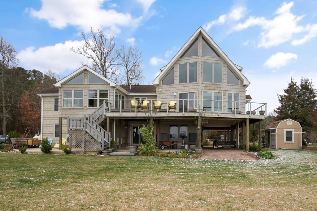 Spectacular contemporary waterfront home on Onancock Creek. The finished ground floor is an ideal space for a kids' playroom, recreation area, or additional living space. The main level offers a cozy living room tucked toward the back of the home, seamlessly opening to the den and showcasing panoramic views of Onancock Creek. The spacious kitchen flows beautifully into the den and dining area, creating an inviting setting for entertaining and everyday living This level includes two well-appointed bedrooms (one with an ensuite bath), a private office that leads to a sunroom perfectly positioned to capture breathtaking water views, and a convenient laundry/full bath combination. The upper level features a stunning loft-style primary suite, designed to maximize sweeping water views.