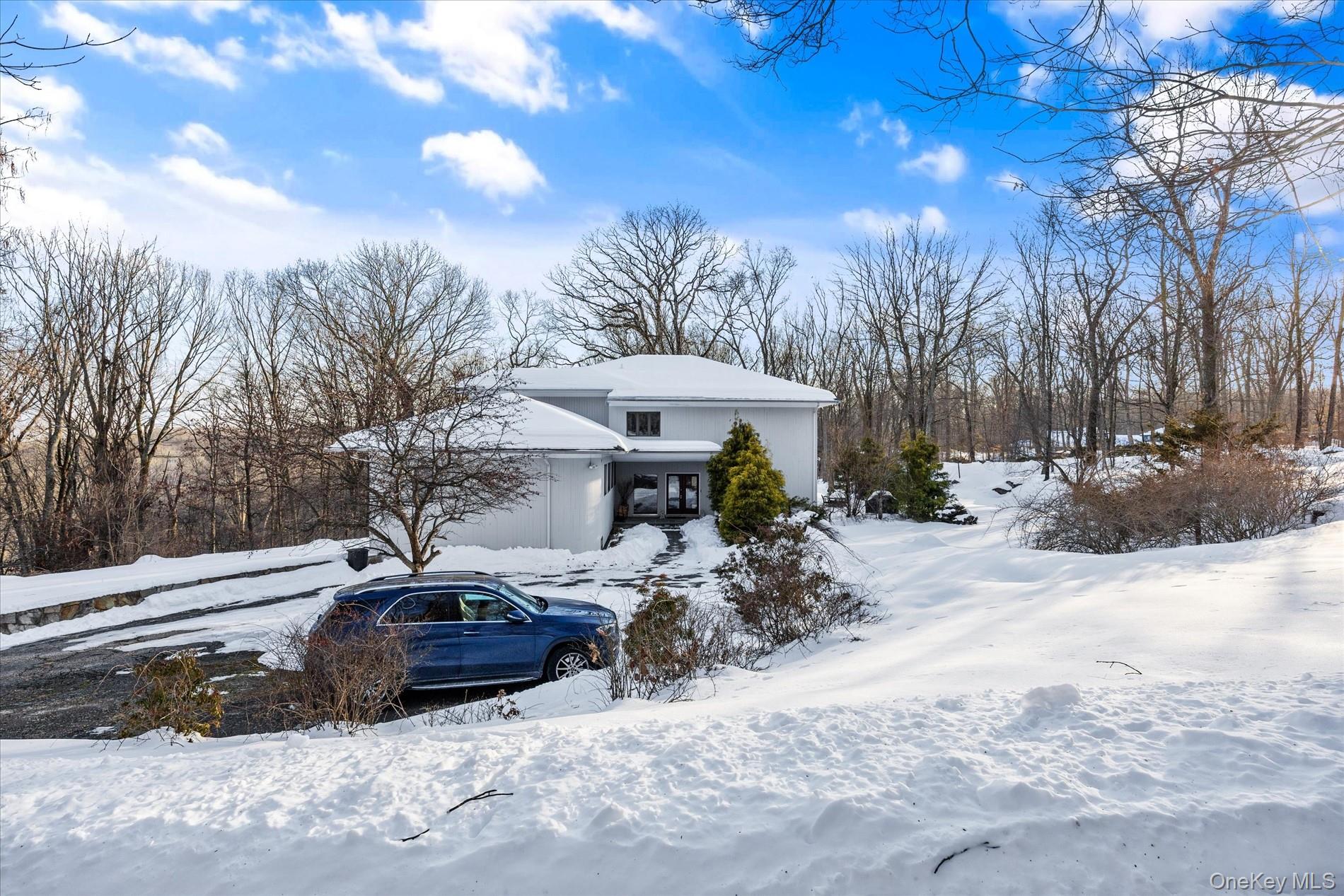 This magnificent residence embodies quintessential Bedford living, gracefully set on a quiet, picturesque cul-de-sac. Ideally located just minutes from Bedford Village and Pound Ridge, the home offers effortless access to the Mianus River Gorge and miles of pristine scenic hiking trails.A gracious entrance foyer introduces the main level, where a dramatic living room showcases soaring ceilings, an open-concept design, and walls of windows framing tranquil woodland views. A stunning stone fireplace serves as a focal point, creating an atmosphere that is both refined and inviting. The impeccably designed chef’s kitchen features custom cabinetry, premium stainless-steel appliances, and seamless flow into the formal dining room—perfect for elegant gatherings. A sun-drenched breakfast nook provides an intimate setting for morning coffee. Rich wood floors extend throughout the home, enhancing its timeless sophistication.Thoughtfully designed for both elevated entertaining and comfortable everyday living, the home offers exceptional flow and flexibility. A few steps up, three generously proportioned bedrooms are complemented by a newly renovated full bath.The upper level reveals an expansive, light-filled loft overlooking the living room, complete with a fireplace and ideal as a refined lounge or library. This level leads to the serene primary suite, featuring a spacious walk-in closet and a beautifully appointed spa-like bath with a soaking tub. An additional large room off the loft offers endless possibilities as a private office, guest suite, or creative retreat.The lower level offers a private rear entrance with direct access to both the main living area and the basement. This level includes a dedicated laundry area with a new washer and dryer. A stylishly updated powder room adds convenience, while the newly renovated basement features new windows, refined flooring, a versatile bonus room, and an updated full bath.Completing this exceptional property is a spacious two-car garage, offering both functionality and convenience.A true MUST See!