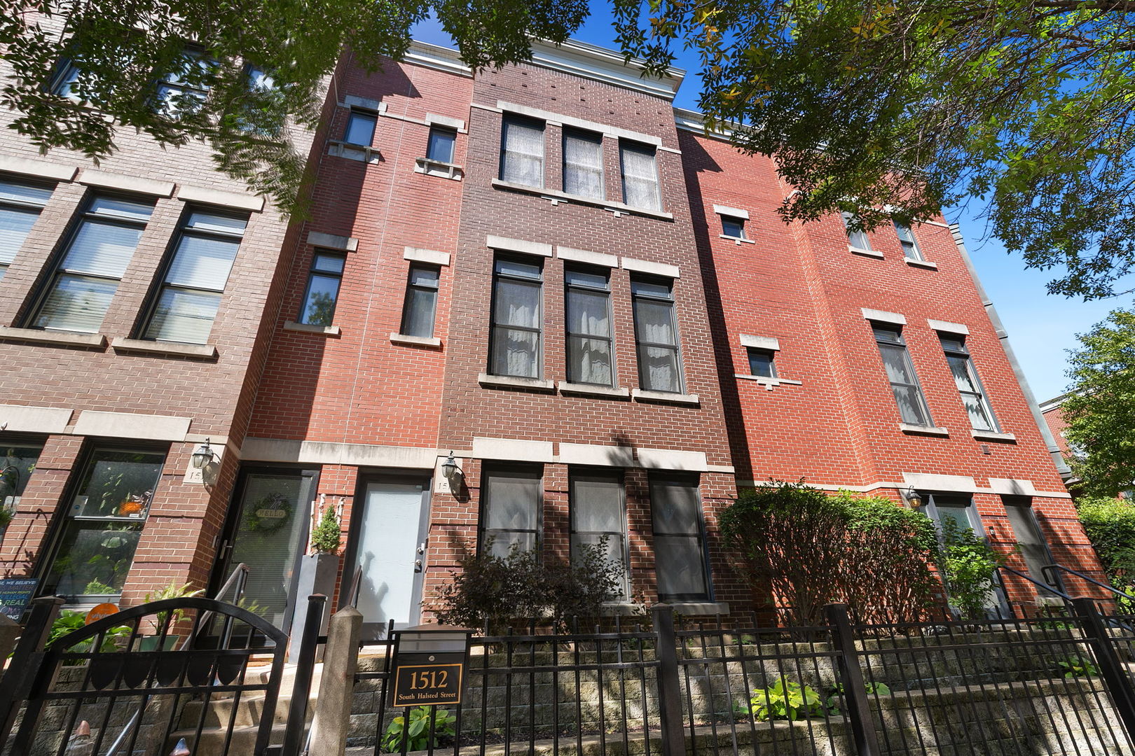 Beautifully updated University Village townhome private gated entry. The main level features an open-concept living and dining room with hardwood floors, a cozy fireplace and floor-to-ceiling windows that let in tons of natural light. The spacious kitchen offers stainless steel appliances, granite countertops, a pantry closet and direct access to a private balcony-perfect for morning coffee or grilling. A convenient half bath completes the main floor. Upstairs, the primary suite boasts dual closets, a ceiling fan, and a private bath with dual vanity and soaking tub. The second bedroom is generously sized and complemented by an updated hall bath with a walk-in shower. Laundry is also conveniently on the second level. The lower level offers a versatile family room, ideal for extra living space, a home office, or easy conversion to a third bedroom. Enjoy breathtaking skyline views from the private rooftop deck, perfect for entertaining or relaxing. Attached 2-car garage and freshly painted (8/2025). Improvements include new AC and boiler (11/2020), fully renovated bathrooms with new Kohler bathtub, walk-in shower, wall cabinets, sinks, and vanity cabinets (2/2024). Conveniently located just blocks from 90/94, Halsted Street Metra, and local bus routes.