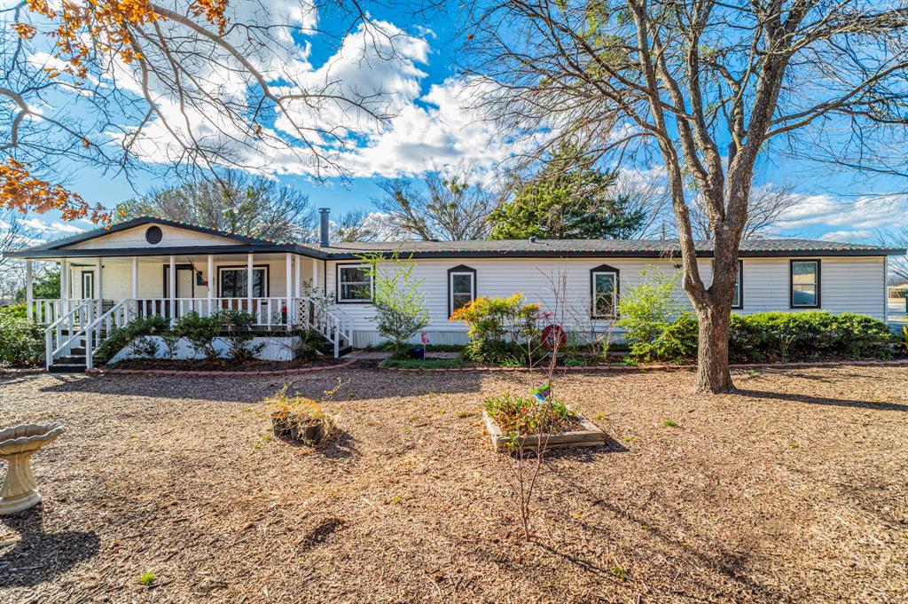 Charming country home set on a spacious, tree-shaded lot offering privacy, functionality, and room to enjoy the outdoors. This inviting property features a welcoming covered front porch, mature trees, a butterfly garden, and thoughtfully designed outdoor spaces that create a peaceful setting.Inside, the kitchen is the heart of the home, showcasing painted cabinetry, subway tile backsplash, ample counter space, and a large island with seating, perfect for gathering and everyday living. The open layout flows easily into the living and dining areas, enhanced by wood-look flooring and abundant natural light.The primary bedroom offers generous space and a private en-suite bath featuring a double vanity and oversized walk-in shower. Secondary bedrooms are well sized, and an additional bathroom provides convenience for guests or family.Outdoors, enjoy a fenced gardening area ideal for growing vegetables or flowers, along with a charming treehouse or chicken coop that adds character and versatility to the property. A dedicated outdoor entertaining space includes a fire pit and seating area, perfect for relaxing evenings. A detached workshop or storage building provides ample space for hobbies, projects, or additional storage.This property offers the comfort of country living with room to spread out while still providing easy access to the city. A unique opportunity for those seeking space, charm, and a lifestyle connected to nature. Solar panels help reduce monthly energy bills. Recently replaced windows, roof and HVAC.