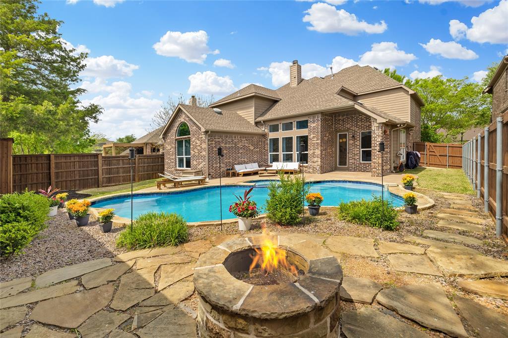 Tucked at the end of a quiet cul-de-sac near the lake, this home offers privacy, space, and a setting that feels both peaceful and inviting. Surrounded by well-maintained landscaping, it makes a strong first impression from the moment you arrive. Step through the front door into a home that feels refined and thoughtfully designed, where clean finishes and natural light set the tone. Fresh Benjamin Moore paint and stylish updated lighting run throughout, giving the home a cohesive, move-in ready feel. Just off the entry, the formal dining room features picture frame molding and a statement chandelier, creating a warm and elevated space for hosting. The main living area opens with a wall of windows overlooking the backyard, filling the space with natural light. A fireplace anchors the room, making it ideal for both everyday living and gathering with friends and family.The kitchen is both functional and refined, with granite countertops, shaker-style cabinetry, and a newly installed Italian tile backsplash. It flows seamlessly into the breakfast area and living space, making it the true heart of the home. The first floor includes a private guest suite, while the spacious primary bedroom offers a comfortable retreat with high ceilings, pool views, and a spa-like bath. Upstairs, three generously sized bedrooms provide comfort and flexibility, while the expansive game room and media room, complete with a built-in desk and custom Murphy bed, offer a versatile space for entertaining, working, or hosting overnight guests. Outdoors, the home truly shines. The covered patio overlooks a sparkling pool and spa, creating a peaceful setting for relaxing evenings. A dedicated firepit area invites gathering and connection, making the backyard feel like your own private retreat. Additional highlights include EV charging in the garage, combining modern convenience with everyday functionality.