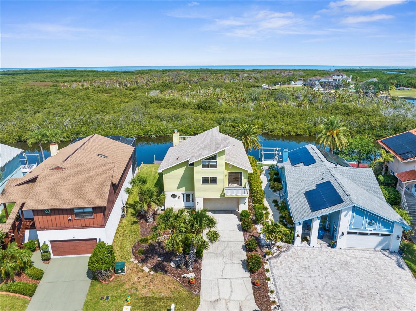 Waterfront Luxury with Peace of Mind – New Roof January 2025! This elevated waterfront retreat sits 14 feet above sea level, offering stunning Gulf views and protection from recent storms. Thoughtfully updated, it features a brand-new roof (2025), new HVAC system (2022), hot water heater (2018), and a 10,000 lb boat lift with electric (2018)—ideal for serious boaters. The home blends style and function with Hardie board siding, remodeled bathrooms, and multiple balconies and covered porches—both screened and open-air—perfect for entertaining or unwinding. The second level showcases a spacious great room with vaulted 17' ceilings, a cozy wood-burning fireplace, and a gourmet kitchen with wood cabinetry and granite countertops. The adjacent breakfast room opens to a shared balcony, creating a seamless indoor-outdoor flow.
Three bedrooms open onto patio decks, two with private balconies. A fourth bedroom or bonus room connects to a third-floor balcony via a charming walkway. Outside, the expansive backyard deck is a front-row seat to dolphins, manatees, and Gulf sunsets.
Located in an amenity-rich community with access to a private boat ramp, floating dock, clubhouse, tennis courts, pool & spa, and  membership to the Gulf Harbors Private Beach Club. Just minutes from top-rated restaurants, shopping, and entertainment.
Don’t miss this rare chance to own a stunning, move-in-ready waterfront oasis!