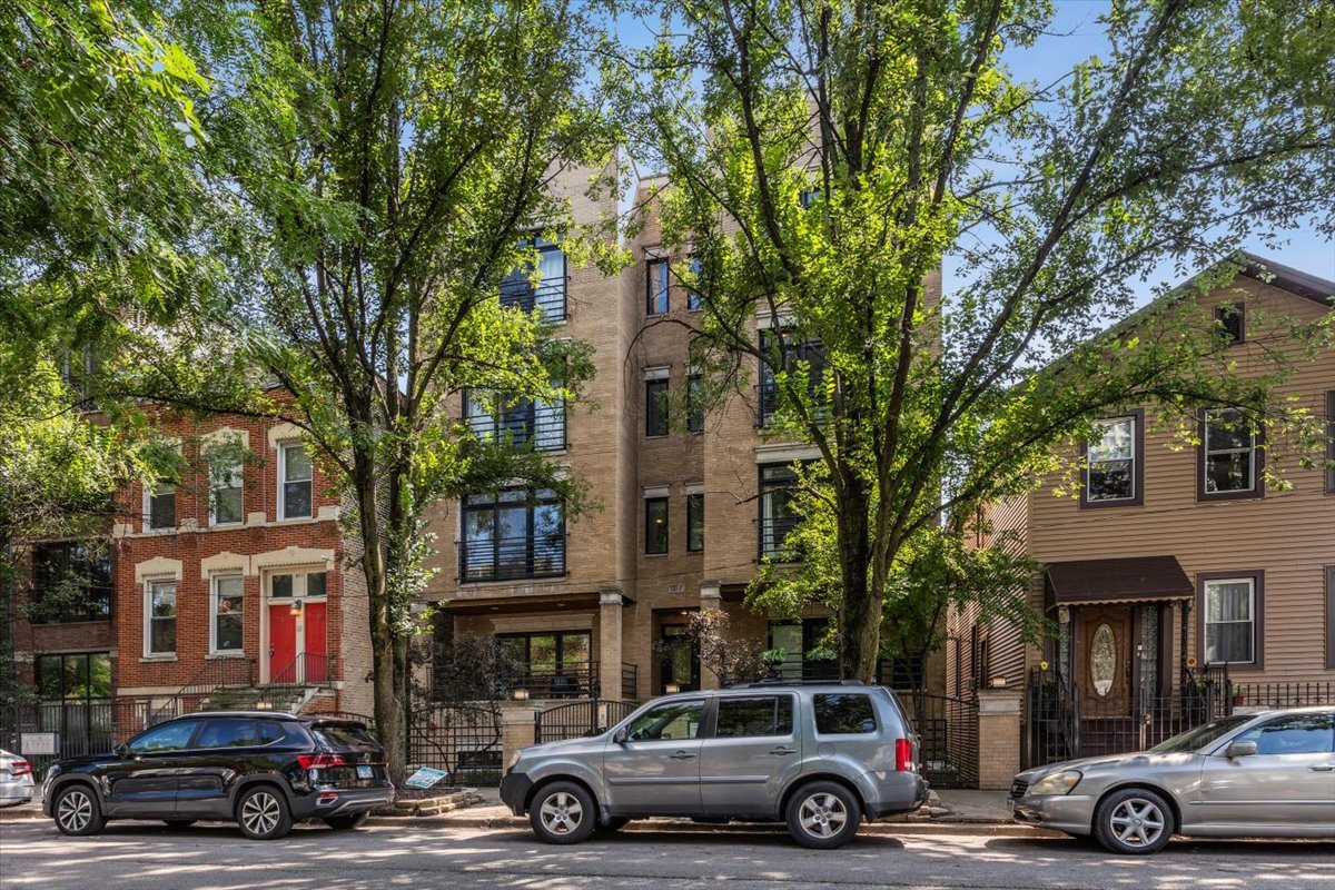 Looking for a space where weekends start with coffee at the kitchen island, continue with strolls to Division Street brunch spots and evenings are spent entertaining friends on one of three outdoor spaces? 1455 W Thomas #1E is a beautifully updated extra-wide 3 bed / 3 bath duplex in a well-managed, all-brick building steps to everything Wicker Park has to offer.   Inside, the main level offers two spacious bedrooms and two full baths, along with an open living and dining area made for hosting holidays or cozy nights in. The updated kitchen (2021) features gorgeous white + navy shaker cabinets, sleek quartz counters, stainless steel appliances and tons of prep space.    Downstairs, soaring 12-foot ceilings create a bright, airy family room that feels perfect for movie nights, while the third bedroom and full bath give flexibility for guests, WFH, working out or a future nursery. Custom built-ins add warmth and storage, while a dedicated office nook makes working from home easy.     Recent updates (2021: kitchen, baths, paint, carpet, lighting, Elfa pantry system and Nest thermostat) mean you can move in and start your next chapter right away. With an attached heated garage, a well-managed association, and unbeatable access to the Blue Line, Division Street dining, and neighborhood parks, this home is where city living meets comfort and connection.