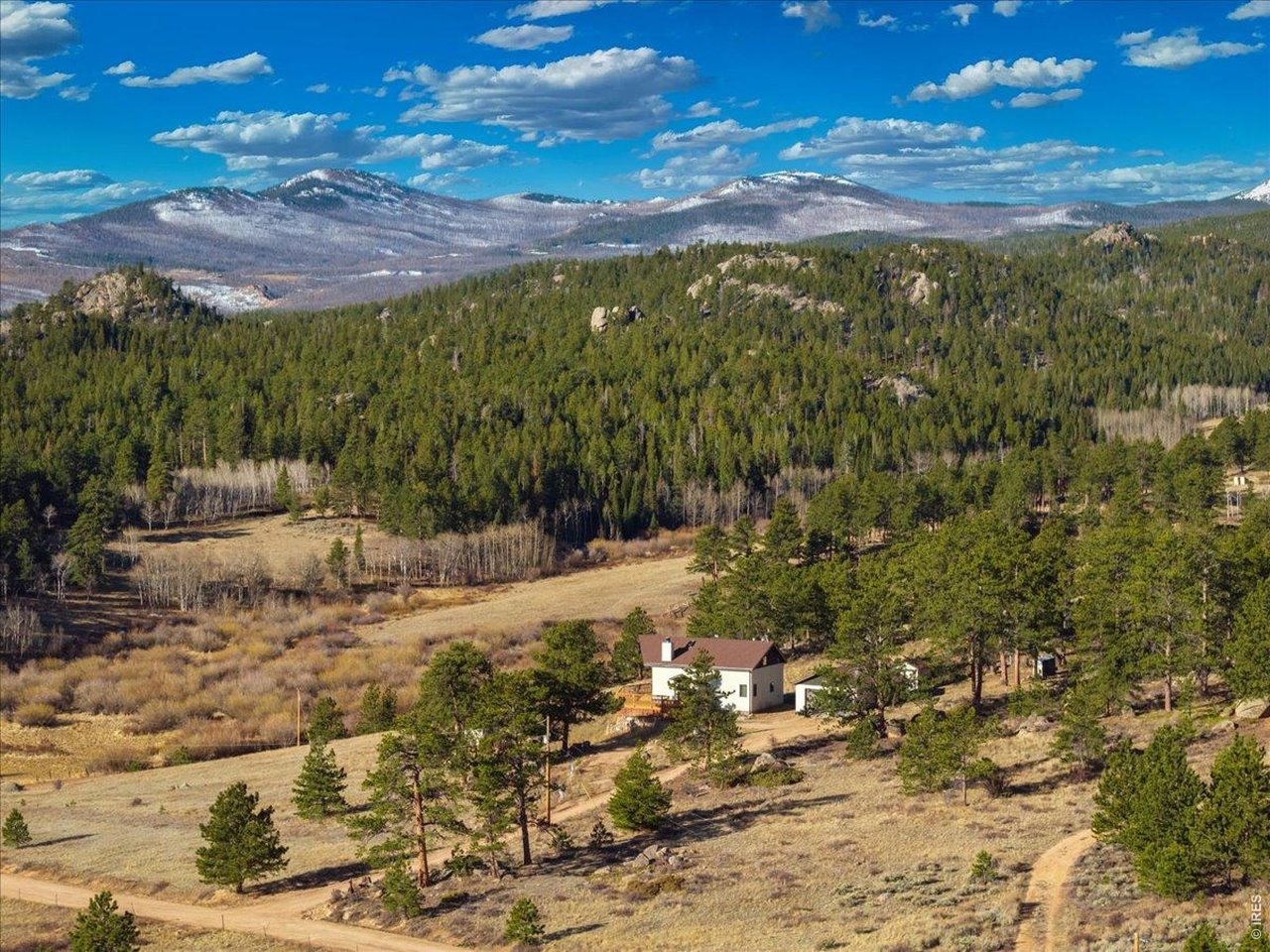 Nestled in the mountains of Northern Colorado, this amazing private home with no HOA offers outstanding views through its floor-to-ceiling windows, which also provide excellent solar gain to keep heating costs low. The 2-bedroom, 3-bath house features beautiful cabin finishes, including a floor-to-ceiling rock fireplace, knotty pine tongue and groove, built-in storage area, unfinished basement, and a spacious deck overlooking the scenery. Situated on 2.66 acres adjacent to Roosevelt National Forest, the property ensures extra privacy. Additional amenities include a two-car garage, wood shed, large storage shed, private well, full septic system, RV parking, electric, and sewer connections. Home is close to several restaurants and stores, 5 public lakes, 8 private lakes, great atv riding a short trailer tow away, hunting just steps away.