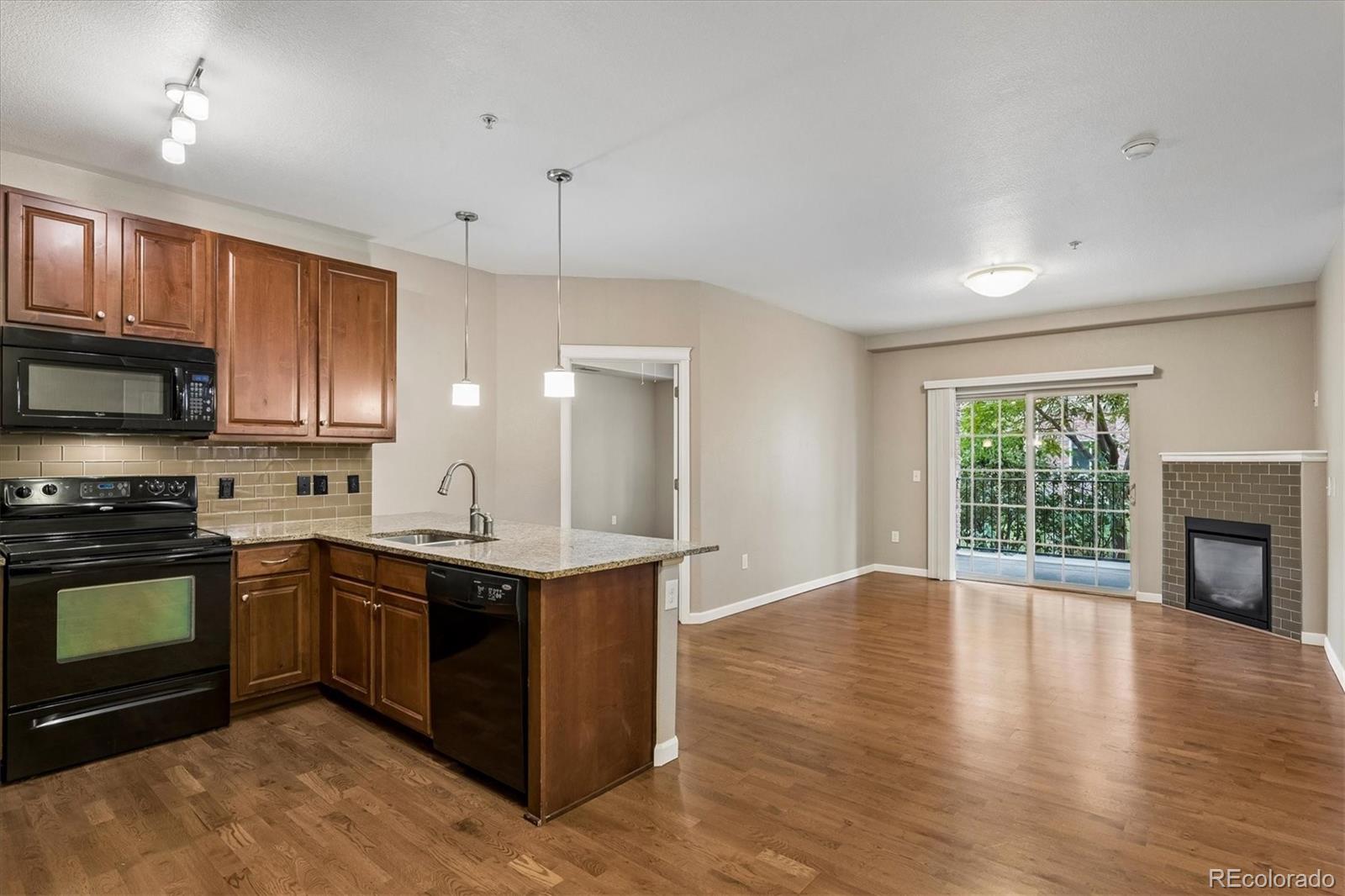 No stairs living and priced to SELL!! This main-floor residence, previously the model home, is designed for effortless living, with a layout that moves smoothly from space to space and a look that's clean, modern, and ready for you to move right in. The moment you walk in, polished floors lead you into a bright, open living area. The kitchen takes center stage, dressed in granite counters that pair everyday function with a refined look with a breakfast bar. Just off the kitchen, the living room offers an easy, open flow ideal for hosting. A gas fireplace adds warmth and ambiance, perfect for settling in on a cold Colorado night. The primary bedroom is a true escape, roomy enough for king-sized furniture, with a spacious walk-in closet and your own private bathroom. The second bedroom brings in plenty of natural light and sits right next to its own bath. Sliding glass doors lead from the main living space out to an oversized covered patio with peak-a-boo mountain views — your own secluded area to relax outdoors. The location is hard to beat. You're just a short walk from Highlands Ranch Town Center Square, surrounded by great restaurants and shopping. You'll also enjoy a reserved space in the building's secure, heated underground garage, with elevator access to all levels, plus a private storage unit — great for gear, decorations, or anything else you need to tuck away. Ownership also unlocks full access to all four resort-style rec centers — Northridge, Southridge, Eastridge, and Westside — complete with top-notch fitness centers, pools, and tennis courts.  You also can access all the open space trails for a serene walk or a great workout!
