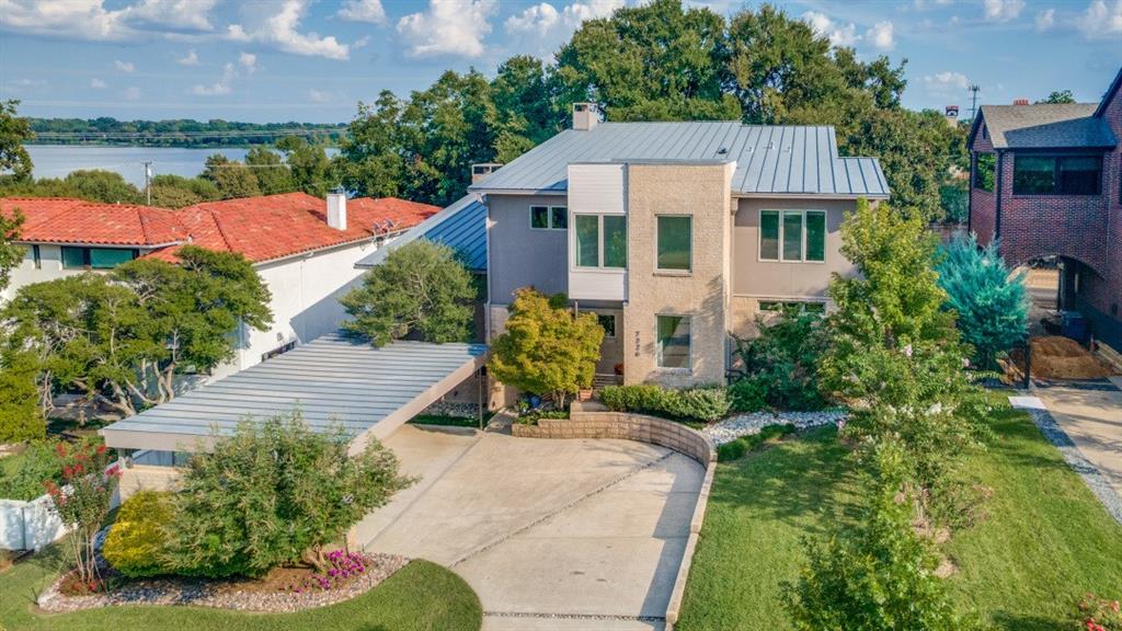 On one of Lakewood's most prestigious street. This Modern Contemporary offers a front seat to the the shimmering beauty of White Rock Lake. The uniqueness of seeing daily lake views, unbeatable access to the shoreline and its vibrant wildlife makes this residence truly one of a kind. A bold sculptural drive-up makes an unforgettable first impression. While inside, the atmosphere balance sleek modern amenities with inviting warmth.  Fresh paint accents the home’s clean lines and open-concept floor design. A chef’s kitchen with wet bar, quartzite countertops, anchors the main living space complemented by custom  grain matched walnut cabinetry. A separate entrance catering kitchen is adjacent to the media room Every detail has been designed to impress. Museum-quality walls and soaring ceilings provide the backdrop for art of almost any size. At the heart of it all is a showstopping, climate-controlled 600-bottle wine library—complete with rolling ladder and views of the pool and lake beyond—designed for the serious collector who loves to entertain and protected by a full-home Generac generator. Floating, glass-railed staircases connect each level, adding understated drama throughout. Almost every room in the home captures a view, with the primary bedroom—located on the main floor—enjoying especially stunning sightlines. The primary bathroom brings the beauty of the outdoors inside with a serene retreat, featuring grain-matched cabinetry and thoughtfully designed closets for everything. Outside is a private retreat: a luxurious pool framed by an expansive Ipe wood deck, freshly stained to complement the architecture. The setting is ideal for relaxing afternoons and lively summer gatherings. Just beyond, White Rock Lake offers beautiful views and easy access to trails, sailing and birdwatching, while the historic fish hatchery is just around the corner—offering a forest at your fingertips  A daily invitation to unwind.. This is more than a home—it’s a modern masterpiece.