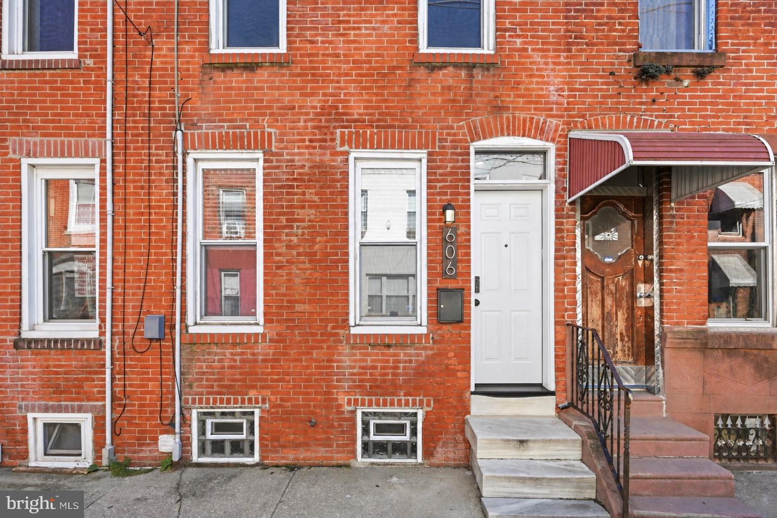 Exposed brick, warm hardwood floors, and a private backyard - 606 Gerritt Street brings together classic South Philadelphia character and everyday convenience. With approximately 1,275 square feet, two generously sized bedrooms, and one-and-a-half baths, this inviting home offers comfortable living close to Passyunk Square’s restaurants, cafés, and shopping.Inside, a striking exposed brick wall stretches along the main living space, complemented by hardwood floors, recessed lighting, and a wood staircase with crisp white trim. The open living and dining area provides ample room for a comfortable sectional and a dining setup, making it easy to settle in or gather with friends. An added main-floor powder room is a welcome bonus. Through an arched doorway, the updated kitchen features white Shaker-style cabinetry, dark countertops, a subway tile backsplash, stainless steel appliances, gas cooking, and tile flooring. Direct access to the large rear patio makes outdoor dining and entertaining easy. With freshly painted walls, this enclosed outdoor space is ready for a grill, seating, and your favorite planters! Upstairs, hardwood floors continue through two well-proportioned bedrooms. The second bedroom comfortably accommodates a queen-size bed, offering useful space for overnight guests or a bedroom and office combination. A full bath with tile flooring and vanity storage completes this level. Additional features include HVAC, a new front door, and an unfinished basement with laundry and ample storage. Enjoy coffee at nearby Herman’s, explore the dining and shopping around Passyunk Square, and come home to the warmth, space, and character of 606 Gerritt Street.
