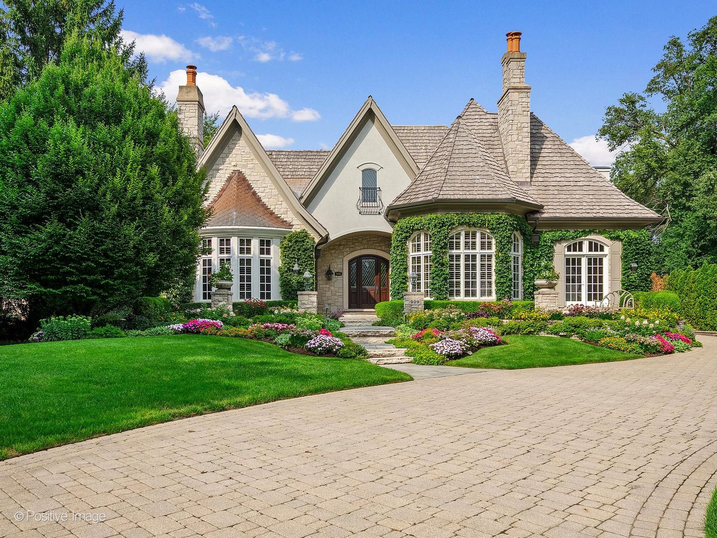 A rare offering of extraordinary craftsmanship, timeless architecture, and refined luxury, 909 Cleveland Road is a true Hinsdale masterpiece. Set on an impressive 98' x 220' half-acre homesite, this exceptional residence offers over 10,000 square feet of beautifully finished living space across three remarkable levels. Custom-built by premier local builder W. H. McNaughton Builders as his own residence, the home showcases exceptional craftsmanship and attention to detail throughout. A dramatic octagonal grand entry and soaring foyer create an unforgettable first impression with exquisite stone flooring, extensive millwork, a custom Murano crystal chandelier, hand-distressed wide-plank French oak flooring, and distinctive architectural ceilings. The beautifully appointed main level features elegant living and dining rooms, an alder-paneled library with a fireplace, and a magnificent octagonal great room with soaring alder beams and a hand-carved limestone fireplace. Just beyond, the home transitions seamlessly to spectacular resort-style outdoor living. A magnificent screened porch with a fireplace opens to a beautiful pool and spa, expansive slate patios, and mature landscaping, creating an extraordinary private setting for entertaining and relaxing. The updated chef's kitchen is equally impressive, featuring furniture-quality cabinetry, quartzite surfaces, Sub-Zero, Thermador, and Bosch appliances, a spacious breakfast room, kitchen office, and pub-style serving center, perfect for entertaining. An incredibly luxurious first-floor primary suite offers volume ceilings, an enormous custom two-sided walk-in closet, and a spa-inspired bath with dual vanities, whirlpool tub, and oversized steam shower. A first-floor laundry, mudroom, two powder rooms, and heated three-car attached garage provide exceptional convenience. Upstairs, four additional en-suite bedrooms feature beautifully redone baths, plus a second laundry room and a study nook. The extraordinary finished lower level is an entertainer's dream, offering a family room with a fieldstone fireplace, expansive game and recreation spaces, a custom Chicago-style pub, an additional bedroom/lounge with a full bath, a gym, a yoga room, a poker room, a wine cellar, a golf simulator room, and abundant storage. Exceptionally well-maintained and ideally located just blocks from Oak Elementary School, BNSF Train, and Town. 909 Cleveland Road seamlessly blends architectural distinction, exceptional craftsmanship, resort-style amenities, and gracious everyday living-an extraordinary Hinsdale residence of rare caliber.