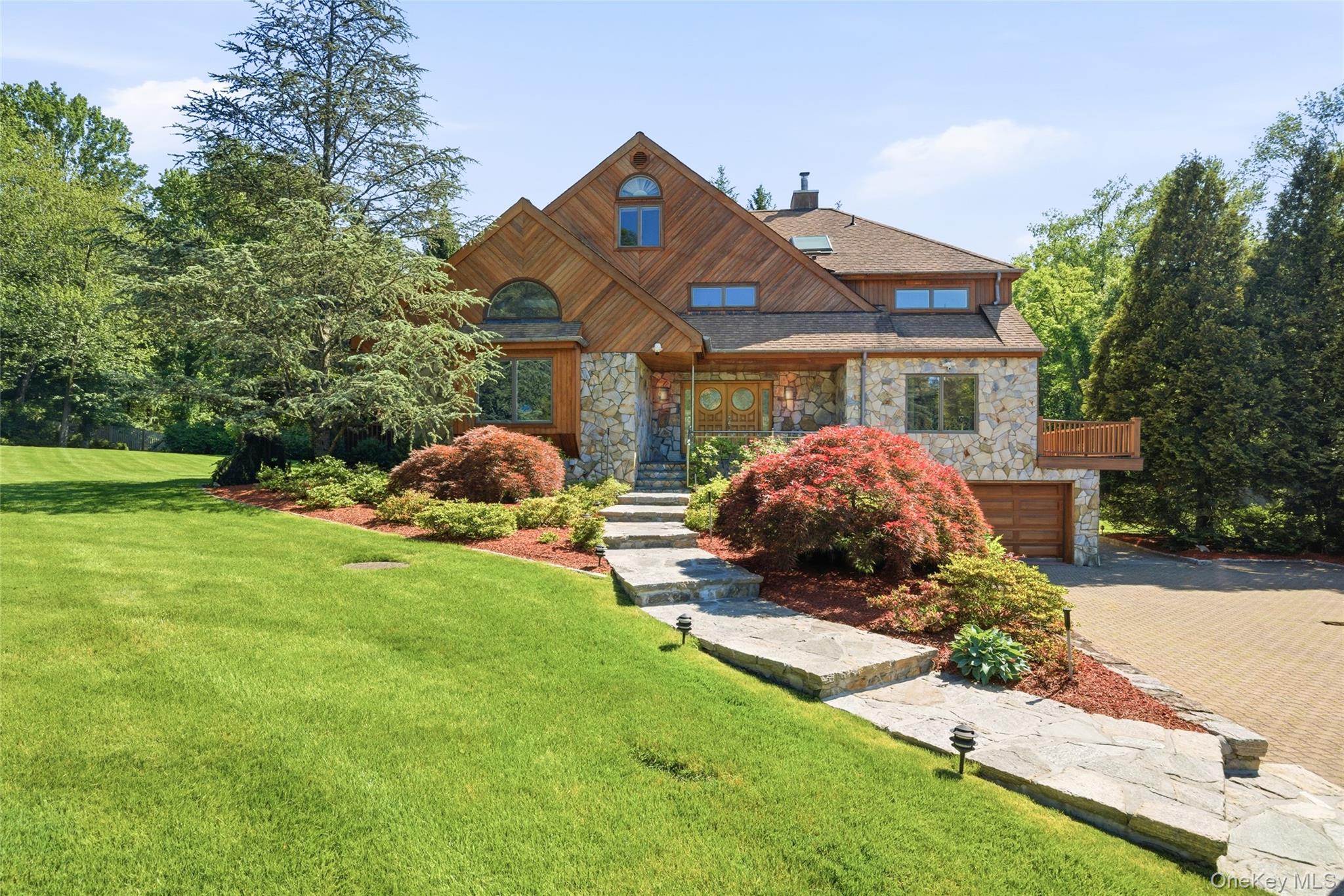 Nestled on over an acre of beautifully landscaped grounds in the highly sought-after Chappaqua School District, this exceptional residence offers a rare blend of privacy, craftsmanship, and versatility. Behind a gated entrance, mature specimen plantings, expansive lawns, and a tranquil natural setting create a true private retreat just minutes from downtown Chappaqua and Metro-North.Thoughtfully improved throughout the years, the home features cedar siding, Anderson windows and sliding doors, custom hardwood flooring with intricate inlay detail, reinforced structural beams, remote-controlled skylights, and numerous mechanical upgrades. Dramatic ceilings, walls of windows, and sun-drenched living spaces create an inviting atmosphere designed for both everyday living and entertaining.The eat-in kitchen is appointed with custom cabinetry, premium stainless steel appliances, a center island, and seamless access to the outdoor deck. Formal and informal living spaces flow effortlessly throughout the main level, highlighted by a dramatic living room with soaring ceilings, oversized windows, and a marble fireplace.The luxurious primary suite serves as a private retreat featuring custom California Closets and a stunning spa-inspired bath with a freestanding soaking tub, oversized glass-enclosed shower with body jets and bench seating, custom mahogany detailing, designer lighting, and exceptional finishes throughout. Renovated bathrooms throughout the home showcase custom tilework, premium fixtures, and thoughtful spa designs.Additional highlights include California Closets throughout, intercom and surround sound systems, smart gate access, surveillance cameras, irrigation system, renovated garage, and a charming detached storage shed. Outdoor living is equally impressive with expansive decking, a remote-controlled SunSetter awning, and peaceful grounds designed for entertaining and relaxation.A truly special offering combining privacy, quality craftsmanship, modern conveniences, and exceptional flexibility in one of Westchester County's most desirable communities.