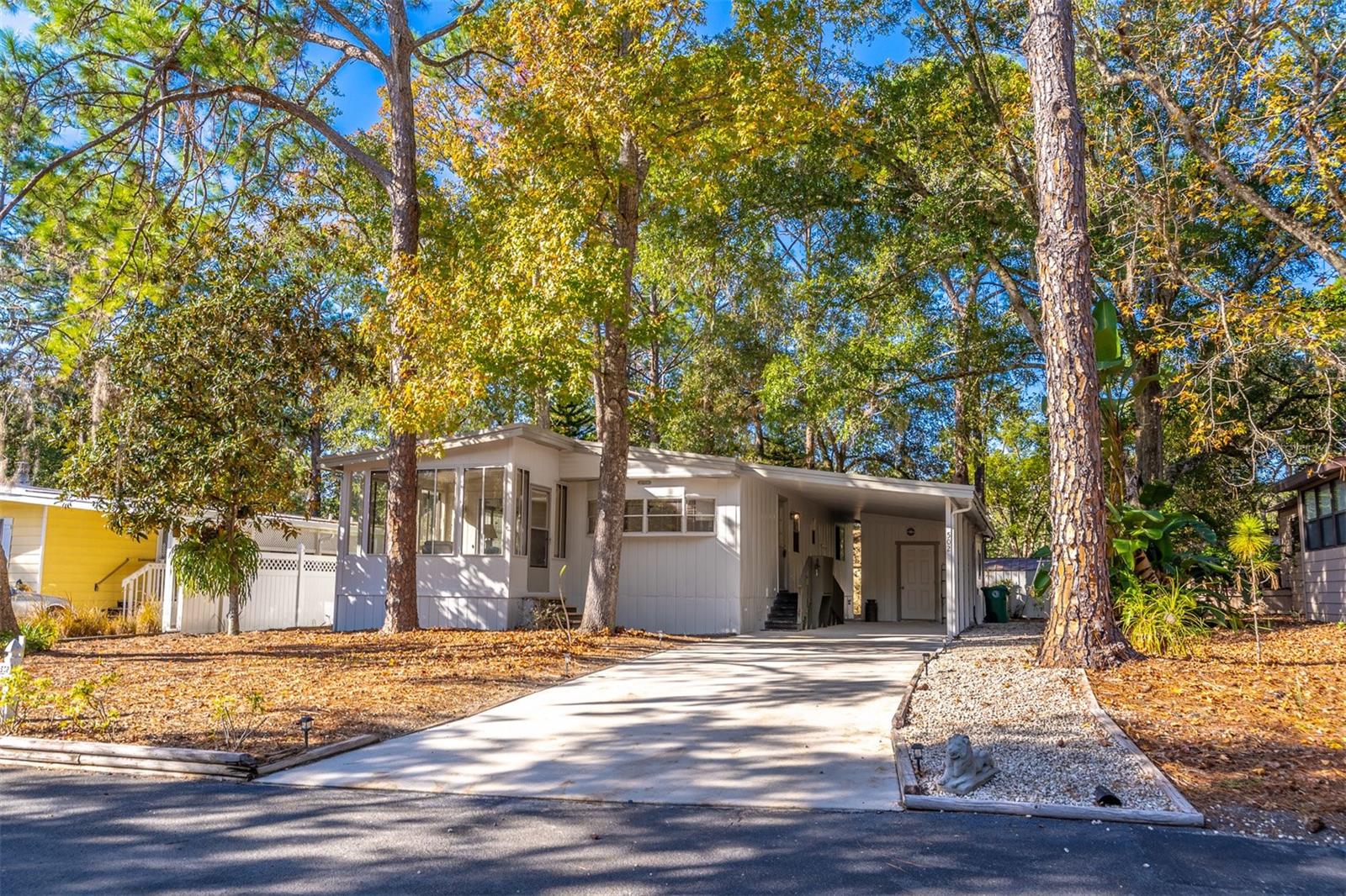 Welcome to The Forest, a true hidden gem tucked away in the heart of Lake Mary. This light, bright, and beautifully maintained 2-bedroom, 2-bath home sits peacefully on a cul-de-sac and offers the rare advantage of land ownership, making it eligible for conventional, FHA, and VA financing.  Built in the 1980s, the home features an open floor plan filled with natural light. The freshly painted exterior adds instant curb appeal, complemented by a long driveway and extended covered carport. Outdoors, you’ll find a large workshop/laundry shed, plus an additional freestanding storage shed in the backyard—perfect for hobbies, tools, or extra storage.  Inside, the kitchen shines with brand-new stainless steel appliances and ceramic tile flooring, opening seamlessly to the main living area. The living room flows into a charming front Florida room wrapped in windows, offering peaceful views of the surrounding natural setting—an ideal spot for morning coffee or evening relaxation. Just steps away are the community’s scenic nature trails, reinforcing the tranquil, park-like feel.  Monthly HOA fees are low and include cable, internet, and trash pickup, adding to the ease of living.  What truly sets The Forest apart is the lifestyle. Residents enjoy two community pools and a beautiful clubhouse with an outstanding architectural design—often described as Frank Lloyd Wright–inspired. The community building offers an impressive array of amenities, including a large gathering room, library, billiard room, poker room, resident coin laundry, craft room, and community mailboxes.  Outdoor recreation abounds with shuffleboard courts, tennis courts, and pickleball courts, while a welcoming social committee hosts monthly events with a full calendar of activities such as cards, pickleball, water volleyball, bingo, and more. One of the most special features of this community is how effortlessly neighbors become friends—you’ll feel welcomed from day one.  All of this is paired with an outstanding location close to I-4 and within walking distance to major shopping and restaurants. Peaceful, social, and perfectly positioned—this is Florida 55+ living at its best.
