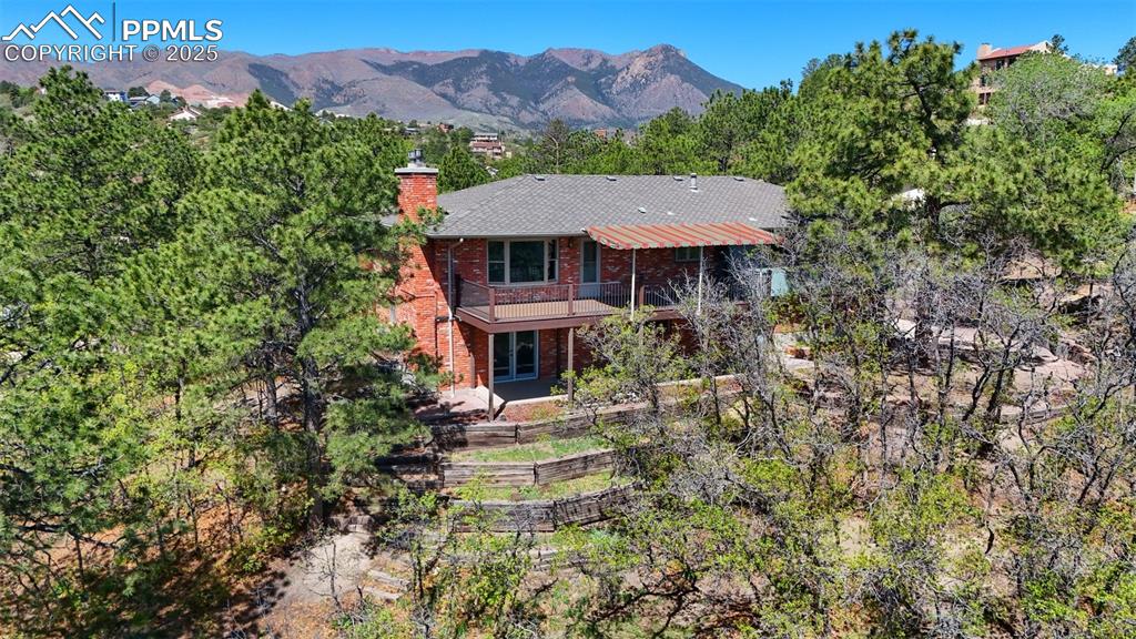 Looking for an amazing home, on an amazing lot, tucked back on a serene & private .62-acre view lot? Look no further, hard to find option on a quiet cul-de-sac in Mount Woodmen Estates / Rockrimmon, delivering a timeless design in the HEART of Northwest Colorado Springs * Surrounded by mature trees with sweeping mountain & city light views, this home is a WINNER * From the moment you walk up onto the spacious front deck, you are welcomed with a true Colorado feel * Upon entry, you will be captivated by the light & bright feel accented by the warm hardwood floors throughout the main level * Enjoy the open great room with bay window (to take in the views) flowing into the dedicated dining area, creating a very functional &  connected space * Spacious eat-in kitchen offers solid-surface counters, cherry cabinets, walk-in pantry & casual dining nook that opens to a cozy family room complete with gas fireplace * Incredible outdoor entertaining space is apparent as you step onto the rebuilt composite deck featuring custom iron railings, expansive awning & breathtaking outdoor living with city light views * The main-level primary suite features a private bath with double vanities and walk-in shower * Two additional bedrooms (one with walk-in closet) share a full bath with jetted tub * Full finished lower level offers a dynamic family room / recreation / game area with 2nd gas fireplace, guest bedroom, huge bathroom redone in Manstone with oversized shower * Bonus / Flex room can double as music, art, office, homework center or additional storage * Spacious walk-in laundry room a bonus * Additional features include an insulated garage with workbench, Newer Furnace, A/C & H2O Htr, Pella windows, newer lighting and plenty of off-street and RV parking * Minutes from top-rated D-20 schools, Air Force Academy, parks, trails and premier shopping * Easy access to I-25, this is a must see, peaceful escape with everything Colorado living has to offer—this one checks every box...