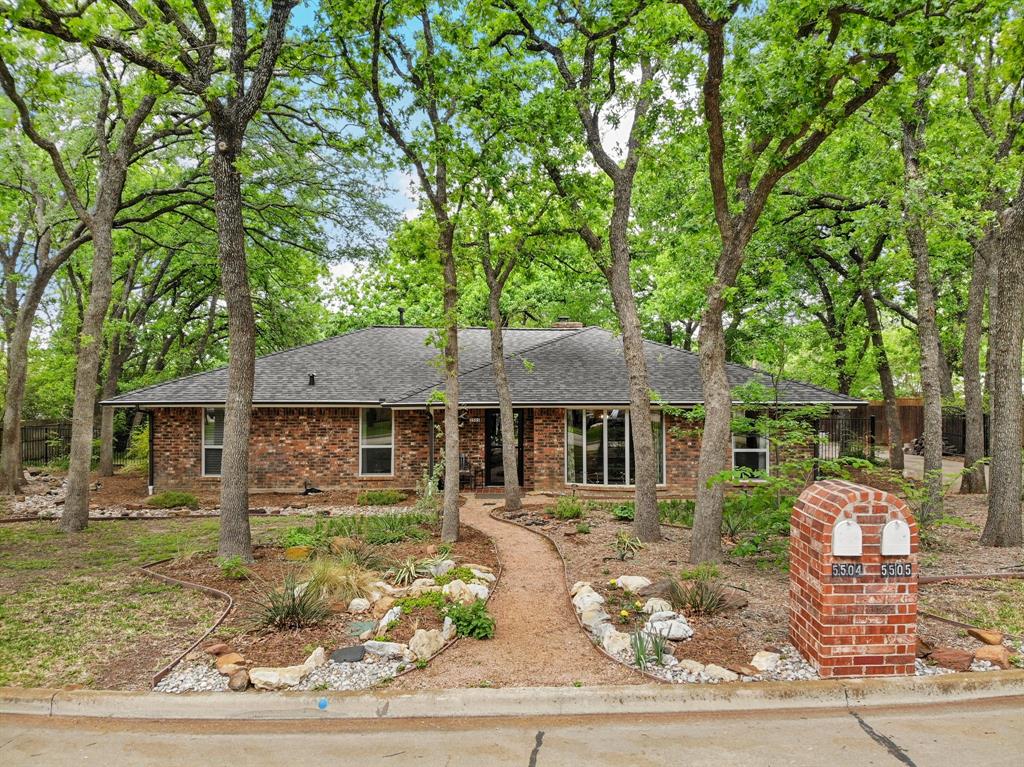 Tucked beneath a canopy of mature trees in Desirable Rustic Oaks Addition, this home offers the perfect blend of charm, character and a peaceful, nature-inspired setting. Beautiful natural Texas landscape giving serene views from nearly every room. Welcome Home to an inviting open layout where your entry and dining space flow effortlessly into the main living area. The showstopper? A stunning floor-to-ceiling brick gas log fireplace paired with gorgeous tongue-and-groove wood ceilings, exposed beams, and rich trim details—bringing true architectural flair with industrial enhancements throughout the home. Unique decorative lighting adds personality and style. Dining area features a large bay window that fills the home with natural light. Enjoy window views from your eat-in kitchen, complete with granite countertops, decorative backsplash, stainless steel appliances, an abundance of cabinet storage plus a charming built-in hutch with character. The oversized primary suite offers a true retreat, with a modern ensuite bath featuring dual sinks, a third vanity space, and a spacious walk-in shower. Secondary bedrooms and bathrooms are also generously sized, providing comfort and flexibility. The home has recently been refreshed with new paint and thoughtfully maintained throughout—Pride of Ownership truly shines. Adding peace of mind to this home - Seller completed a pre-listing inspection and addressed items to ensure the home is in excellent safe condition for the next owner. Step outside and unwind in your own private outdoor oasis, featuring an oversized patio, extended decking, and a cozy cobblestone firepit area—Garden beds include their own irrigation system giving easy maintenance.  Additional highlights include a smart thermostat, front-load washer and dryer that convey, a manual iron driveway gate, French drains, sprinkler system, rain gutters, and radiant barrier for added efficiency. This home is truly move-in ready!