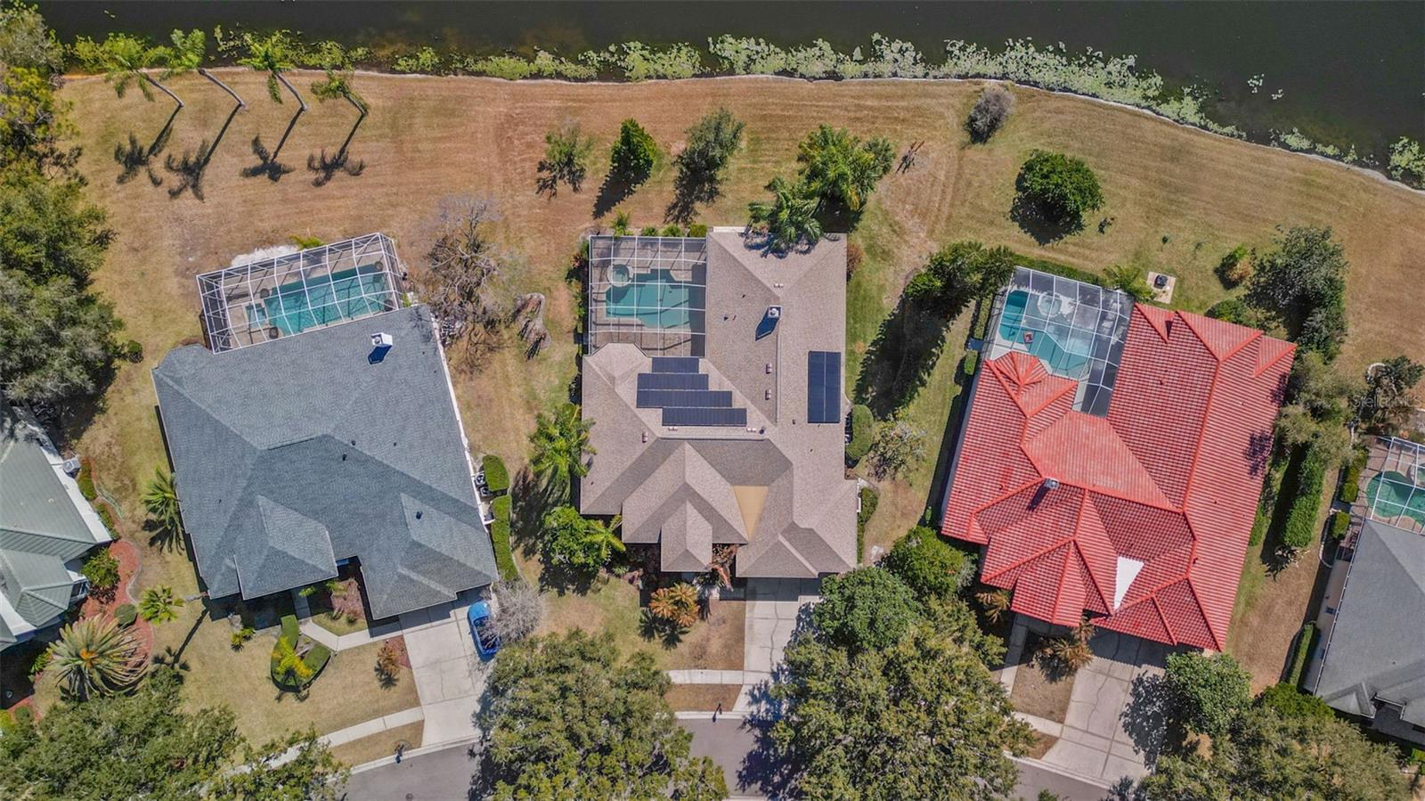 Custom Hannah Bartoletta estate home situated on a 1/4+ acre waterfront pond lot, tucked away on a quiet cul-de-sac in the highly sought-after gated enclave of Huntington at Tampa Palms.  This impressive residence boasts 3,738 square feet of living space, 5 bedrooms plus office, 3 bathrooms, 3-car garage, pool, spa, covered lanai, and stunning water views from nearly every room.  From the moment you arrive, you will feel how truly special this home is.  Walk along the beautifully landscaped pathway leading to the glass double-door entry and into the grand foyer.  Inside, the high ceilings, refined architectural details, custom moldings, 8-foot doors, and sprawling layout create an elegantly sophisticated atmosphere designed to satisfy even the most discerning buyer.  The gourmet kitchen is an absolute chef’s delight, featuring Wolf appliances, including built-in double-ovens, gas cooktop, and professional-grade exhaust hood.  Additional highlights include a Sub-Zero refrigerator, stone countertops, custom backsplash, 42-inch solid wood cabinetry, decorative lighting, expansive island, beverage center, and dinette with a tranquil water view.  The thoughtfully designed split-bedroom floor plan, with separate bedroom wings, offers exceptional privacy and flexibility.  The primary suite is a peaceful sanctuary with a sitting area, walk-in closet, and beautifully appointed en-suite bath.  The formal living room and separate formal dining room provide elegant settings for special occasions, while the family room, lanai, pool and spa create inviting spaces for relaxed indoor/outdoor living complete with a tropical resort-style backdrop.  Great for entertaining, but more importantly, perfect for any lifestyle.  The size, the layout, the craftsmanship, the lot, the street, and the neighborhood combine to make a home of this caliber a rare and remarkable find.  Additional Information: The home is equipped with energy-saving solar panels that have been paid in full.  Central vacuum system runs throughout the entire home.  EV charger ready in garage.  New attic insulation in 2024.  Garage doors replaced in 2024.  Huntington is a gated subdivision within the Tampa Palms community.  Centrally located in the New Tampa area, just south of I-75, near Moffitt, USF, VA hospital, top-rated schools, restaurants, shopping, golf courses, nature trails, parks, playgrounds and more!