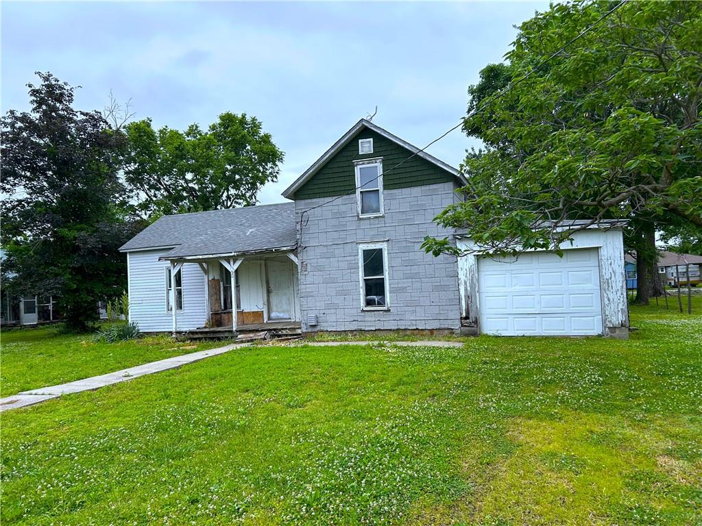 Bring your hammer & toolbox and turn this home into a showstopper once more! This 2 story home has all the bones to be great again. The original hardwood floors are present throughout most of the home.  With some sweat equity this will make a nice family home &/or investment property.  The layout of the home flows well with the living room, kitchen, laundry and two bedrooms all on the first floor. In the kitchen some work has been completed in the past with laminate (granite look) counters, a stainless sink & painted cabinetry.  Add some new floor covering to the kitchen, deep cleaning & refresh the paint and you'll be ready to prepare a meal.  Throughout you'll find places that need wall repair, specifically in the bathroom & laundry areas.  The second story holds two large bedrooms with enough space to spread out. Overall, deep cleaning, a few new windows, wall repair, new exterior siding & new paint and this home could look entirely different!  An attached 1 car garage provides a great space for parking &/or hobbies.  The yard is spacious with lush grass, a small tool &/or chicken shed & an old garden plot that's just begging for you to plant & call your own.  This home sells AS IS.  It's surrounded by beautiful homes with well-groomed yards, making this a perfect fix & flip, or keep as your own, opportunity.