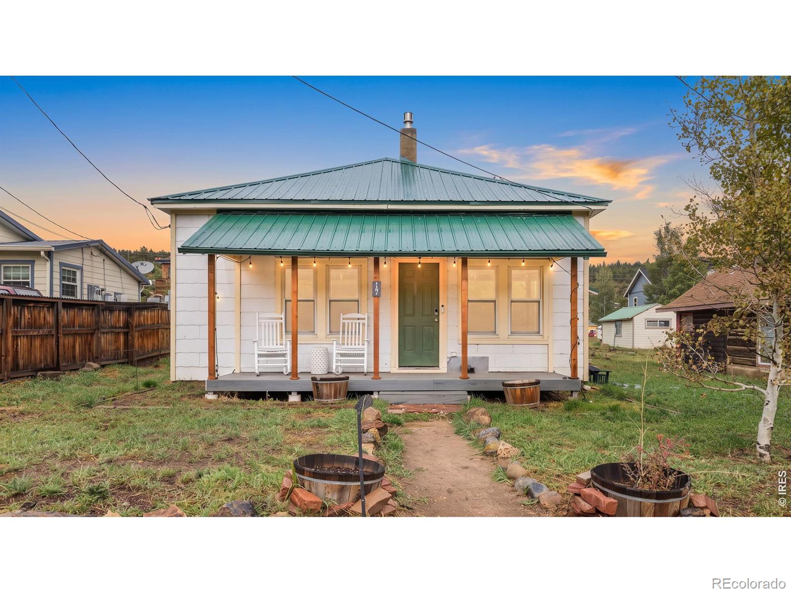 Live in the heart of idyllic Nederland in this charming 100-year-old bungalow, perfectly positioned on a flat double lot along one of town's main streets. Offering the best of mountain-town living, this single-story home is just a short stroll from restaurants, shops, grocery stores, live music, public transportation and Barker Reservoir, with easy access to nearby trails and just minutes from Eldora Ski Resort. A covered front porch welcomes you into a home filled with vintage character and mountain ambiance, with hardwood floors and an inviting open flow between the living and dining areas. A gas fireplace and wood stove add warmth and supplemental heat, while updated fixtures and thoughtful improvements provide modern convenience. The kitchen has been partially updated with newer cabinetry, stainless steel appliances and updated countertops. Adjacent to the kitchen, the remodeled full bathroom features a tub, while a large pantry and storage area provide valuable utility. Three generous-sized bedrooms provide comfortable space for family, guests or a home office if desired. A covered back porch leads to the fenced backyard, with alley access and an oversized attached 2-car garage that connects conveniently to the kitchen. Major improvements include a newer metal roof, updated windows throughout and an owned 8kW solar system installed in 2025. The flat double lot offers space and versatility rarely found in such a central location. This home retains the character and charm of a century-old Nederland bungalow while offering important modern upgrades and infrastructure. It is not completely turnkey and offers an opportunity for a buyer to add their own finishing touches and build upon the improvements already in place. A unique opportunity to own a piece of Nederland history with an unbeatable downtown location, valuable upgrades and plenty of potential.