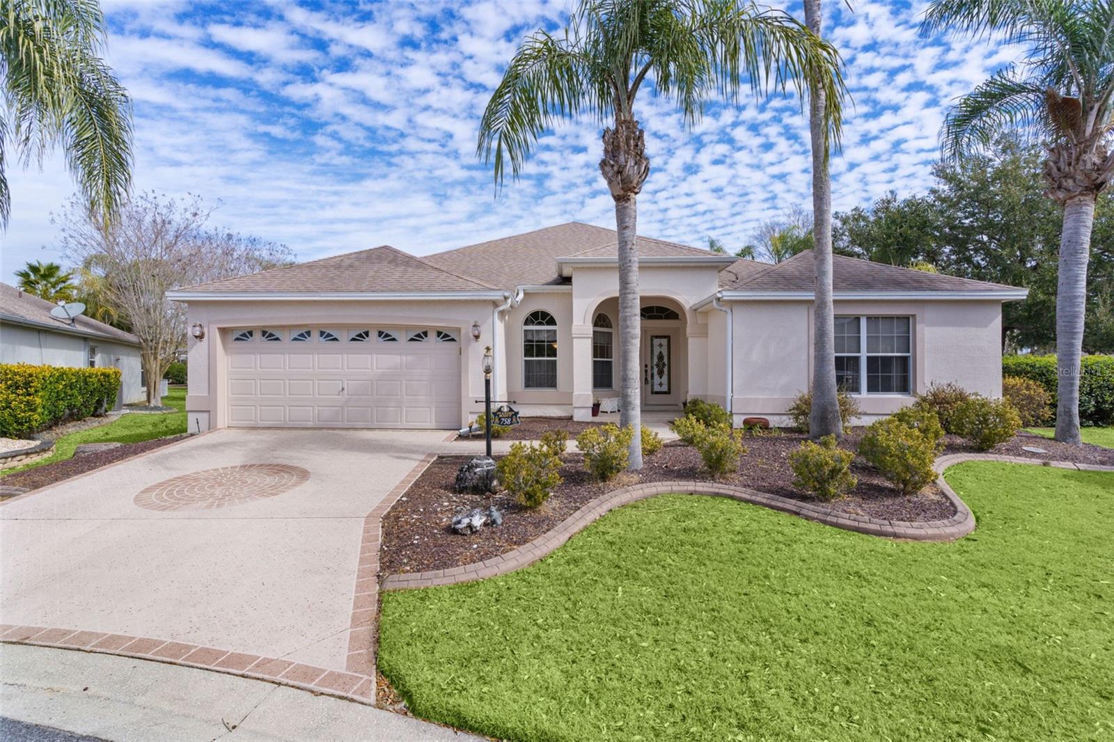 One or more photo(s) has been virtually staged. ~$50,000 PRICE REDUCTION~ ~POOL HOME W/SPA~ ~2020 ROOF~ ~2022 HVAC~ ~2026 HOT WATER HEATER~ ~LARGE SUMMER KITCHEN~ ~LARGE BONUS ROOM~ ~CUL-DE-SAC~ Welcome to your dream home in the Village of VIRGINIA TRACE, perfectly tucked away on a peaceful CUL-DE-SAC with a welcoming PAINTED DRIVEWAY. This stunning EXTENDED GARDENIA floor plan offers the ultimate Florida lifestyle. Step inside to soaring HIGH, VAULTED KNOCKDOWN CEILINGS, CERAMIC tile in the entry, UPGRADED LIGHTING, and an open, airy feel throughout. The living and dining areas feature laminate flooring, with an UPGRADED CELING FAN in the living room and updated lighting, elegant architectural pillars, and high ceilings in the dining room—perfect for entertaining. The gourmet kitchen is both stylish and functional, offering CERAMIC tile flooring, UPGRADED CABINETRY, TILE COUNTERTOPS, a TILE BACKSPLASH, wall oven, rollout shelving, recessed lighting, and a cozy eat-in dining area. The primary suite is a relaxing retreat with plush carpeting, a ceiling fan, vaulted ceilings, and 2 WALK-IN CLOSETS. The primary bath includes DUAL sinks, CERAMIC tile, a WALK-IN TILE SHOWER, garden tub, linen closet, and high tiled countertops. One guest bedroom features carpet, CROWN MOLDING, ceiling fan, built-in closet, and vaulted ceilings. The LARGE guest bath includes a PEDESTAL SINK, CERAMIC tile, a tiled tub/shower combo, and room to add a storage area. The additional guest bedroom is complete with carpet, CROWN MOLDING, ceiling fan, and blinds.  Additional highlights include an INSIDE LAUNDRY ROOM with cabinets, shelving, a built-in ironing board, and GE appliances. The 2-car garage is equipped with COLEMAN CABINETS and painted flooring.  The BONUS ROOM has laminate floors that flow seamlessly through the living area, also with CROWN MOLDING, a chair rail, and dual ceiling fans. Step outside to an EXTRA-LARGE BIRDCAGE enclosing the SALTWATER POOL and SUMMER KITCHEN, ideal for year-round enjoyment. The exterior also features a paved side porch, an open area out back, extensive landscaping, and added peace of mind with a front door camera and alarm system. This exceptional home truly has it all with space, upgrades, privacy, and resort-style living. A must-see in The Villages! Less than a 5-minute golf cart ride to Lake Sumter Landing, and a short ride to Spanish Springs. It is close to the Virginia Trace Adult Pool and Rec Center as well as the Canal Street Rec Center. Close to shopping, dining and medical on CR 466 and around Lake Sumter Landing.