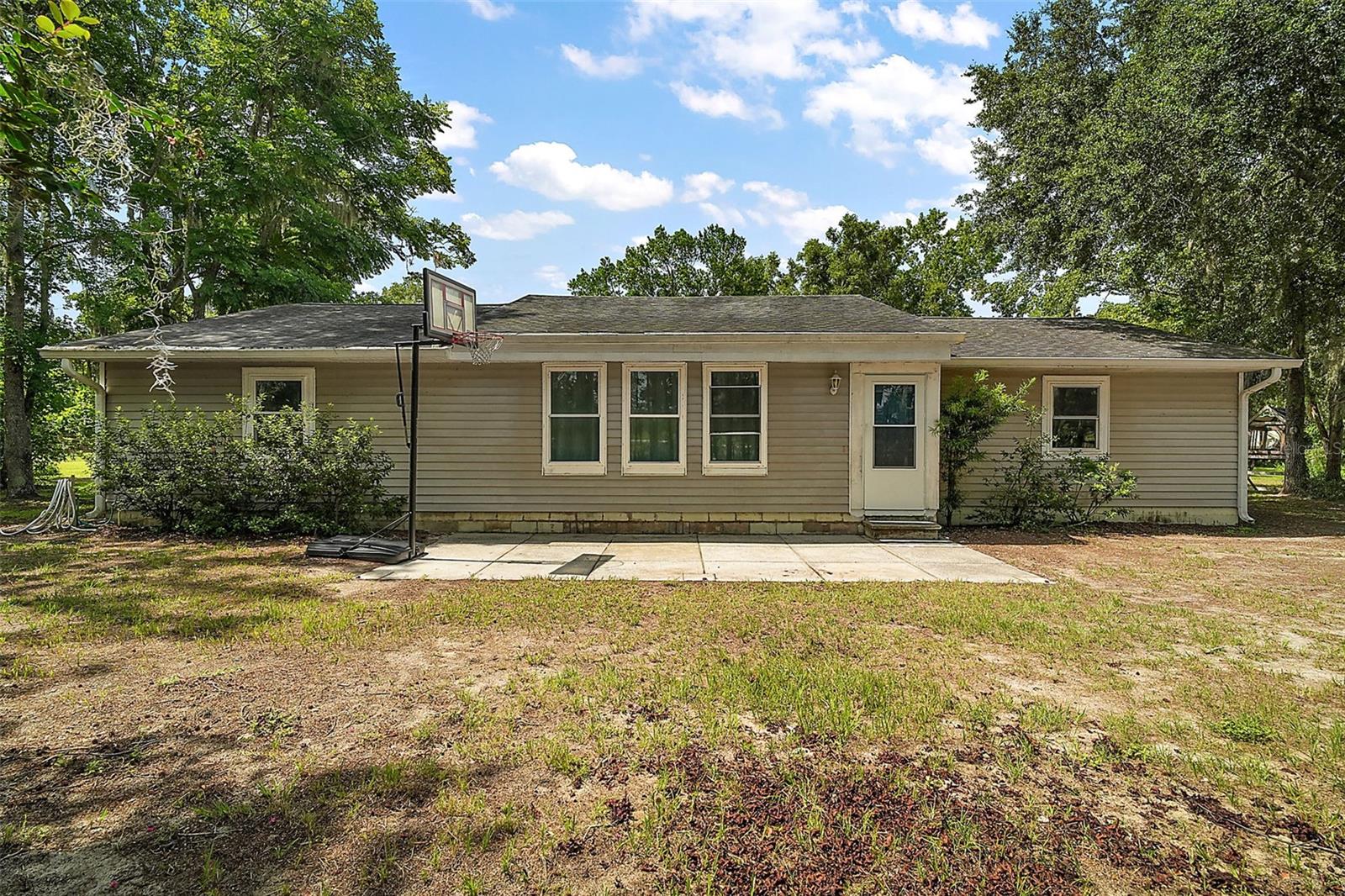 Are you wanting some land to spread out with no HOA fees? Look no further than this beautiful Groveland property on 4.84 acres (3.84 high and dry).  The tree lined driveway leads to a 1800 Sq Ft  3 bedroom 2 bathroom ranch style home.  The freshly painted home boasts of vaulted ceilings with timber beams, tile flooring throughout, newer windows and plenty of natural lighting in the eat-in kitchen. The master bedroom has an en suite bathroom.  The spacious 2nd  bathroom has a soaking  tub and a new shower. Out the back door is a concrete patio for all of your leisure enjoyment.  The roof was replaced in 2017 and double pane energy efficient windows installed in 2020. Wait! That is not all!  The property has a massive 25’x 60’ barn that has an office, a storage area, and a workshop for all of your  needs. In addition there is even a spot to store your boat or RV complete with an electric hookup. A fenced in area can accommodate your animals. Your shopping needs can be conveniently met in nearby Clermont. Numerous lakes as well as Lake Louisa State Park are close by with Orlando and Disney about 40 minutes away.   Hurry and see this exceptional property before it is gone.