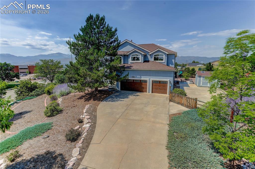 Showcasing stunning views of Pikes Peak and the Front Range, this inviting 7 bed & 4 bath home blends everyday comfort with thoughtful design. A welcoming front living room and adjoining dining area feature soaring two-story ceilings and abundant natural light. The eat-in kitchen offers soft-close cabinetry with crown molding, granite countertops, dual ovens, a walk-in pantry, and an island with bar seating—perfect for gathering. Step outside to a spacious deck overlooking mountain scenery, or relax in the family room complete with a gas fireplace, & wet bar. Upstairs, French doors open to the primary suite with a vaulted ceiling, fireplace, and 5-piece bath with a soaking tub. The lower level includes a rec room with dry bar and dedicated office space for work or play. Additional bedrooms are available on every level of this home, including the option for a main-level guest suite or office. Enjoy outdoor living with a turf yard featuring putting holes, a playground area, and established professional landscaping. The xeriscaped front yard ensures easy maintenance. A 3-car garage, RV pad, and Tuff Shed provide ample storage and flexibility. Located in a peaceful setting with excellent D20 schools, convenient access to I-25, shopping, and restaurants, this property offers comfortable Colorado living with room to relax and enjoy breathtaking sunsets.