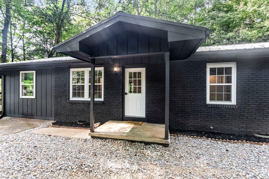 This beautifully updated single story ranch home is nestled on a serene 1.5+/- acres within a quiet neighborhood, featuring a private drive and ample parking. The exterior brick has been revitalized with a fresh coat of paint, and a wheelchair-accessible ramp provides easy entry. Inside, the spacious and bright kitchen seamlessly flows into a combined dining and living area. The kitchen showcases brand-new cabinets and wooden countertops. The home is adorned with new wood flooring throughout, complemented by ceramic tile in the bathrooms. The primary bedroom offers direct access to a covered deck and includes an en-suite bathroom with a walk-in shower. With three additional bedrooms and a guest bathroom, this layout is perfect for family living. The expansive yard provides plenty of outdoor space, while the covered deck serves as an ideal setting for entertaining or simply enjoying the tranquility of nature. Only minutes to town, this property would make a great primary or vacation home.