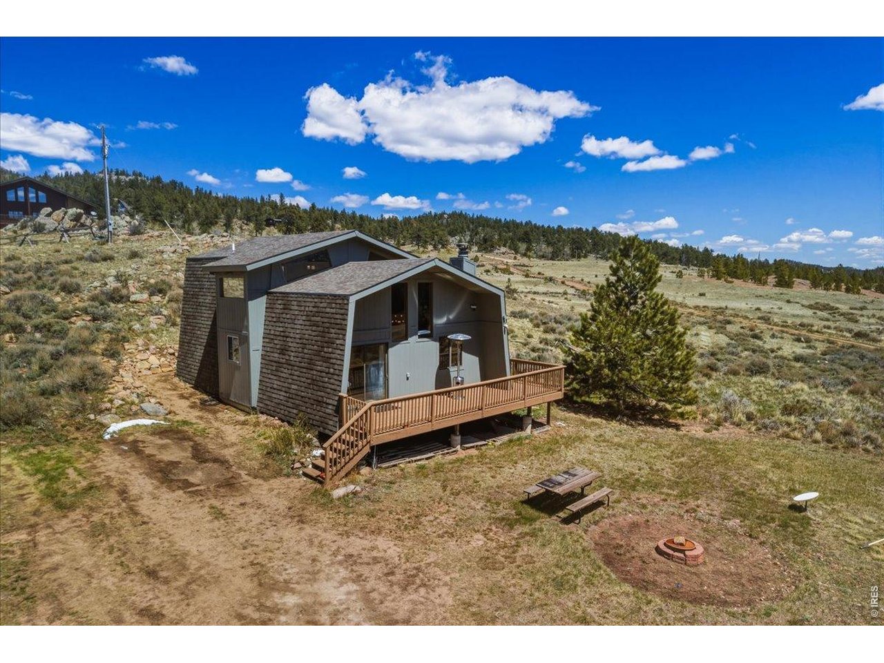 Nestled amidst the picturesque mountains of Northern Colorado, this charming chalet-style home offers exceptional year-round living, complemented by the rare inclusion of a historic Forest Service CCC cabin. The cabin itself features two inviting bedrooms, with the spacious primary suite located upstairs alongside a cool lounge area-perfect for relaxing with a good book or enjoying quiet evenings in. There are two full bathrooms, a convenient laundry area, and a cozy wood stove that adds warmth and character, all set against the backdrop of beautiful knotty pine interiors, custom railings, and brand-new tile flooring that enhance the home's rustic yet refined appeal.Step outside onto the expansive deck, where you can savor tranquil mornings and evenings watching moose and deer wander by, or simply listen to the gentle sound of the river flowing through the valley below. Practical upgrades include a newer roof and fresh exterior paint, as well as a private well and a full septic system. As a resident of Crystal Lakes, you'll benefit from well-maintained and regularly plowed roads, convenient trash drop-off, and exclusive access to private members-only fishing and scenic hiking trails that weave in and out of the community. This unique property embodies the perfect blend of mountain adventure, historic charm, and modern comfort.
