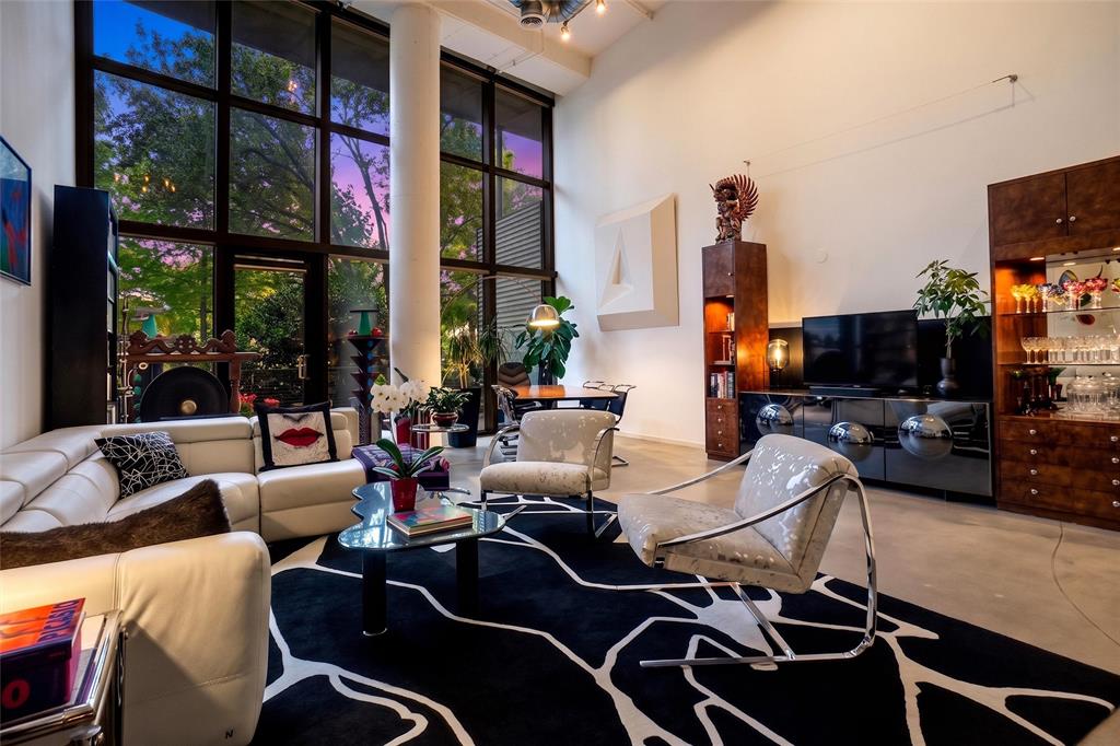 Situated in the historically significant State Thomas, Uptown neighborhood, this residence offers expansive vistas through 18 foot high windows, equipped with motorized blinds, into beautiful Griggs Park. In fall, when leaves drop, a panoramic view of the glittering lights of downtown emerges, all of this is a short walk or drive to the internationally famous Dallas Arts District’s Klyde Warren Park, museums, Symphony Hall, Opera House and Theatre. Unit 121 is one of the largest in the building with a party-size balcony. It is surrounded by shrubs and trees as though your private backyard, with nesting birds, squirrels, a heaven for city dwellers and nature lovers alike. The unit has been entirely updated blending industrial with mid-century design.  Its easy living area features an open kitchen with oversized island, extensive custom cabinetry and abundant countertop workspace, invites bar-style and sit-down dining.Off the entry hall, the downstairs bedroom with a large closet has an adjoining bathroom with shower.  Upstairs, the primary, very spacious master suite offers a hi-tech, spa-inspired bath and walk-in closet.  The loft over the living area could be a design studio, home office, media room or yoga area, all with sweeping views into the park.  Entry to the gated premises leads through the landscaped, bricked terrace that is equipped with gas grilles, seating areas and large screen tv.  The fully equipped gym, next to and leading out the back entrance, past a play-pool, exits right into Griggs Park.  On the 11th floor is the Sky Lounge, free use party room for residents.  This condominium complex is in easily walkable proximity of Uptown premier restaurants, grocery stores, and the Katy Trail.