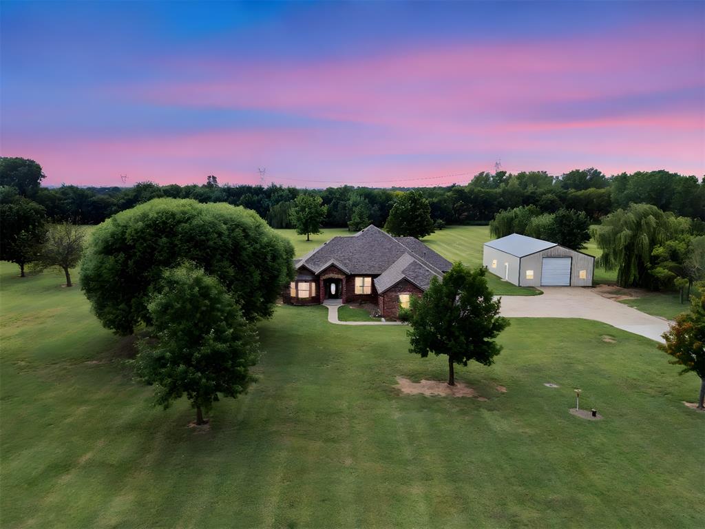 Set back on 5 peaceful acres, this well-kept 4 bedroom, 2.5 bathroom home welcomes you with space and comfort. Step inside to a thoughtful split bedroom layout, where the private primary suite offers a retreat with its large walk-in closet, jetted tub, and walk-in shower with dual showerheads. At the heart of the home, the kitchen provides an abundance of cabinets and counter space, making it easy to gather and prepare meals. The open living areas flow naturally, creating an inviting setting for both daily living and entertaining. Secondary bedrooms are generously sized, each with walk-in closets that add storage and convenience. Just beyond the home, an insulated shop with electric and plumbing is ready for projects, business use, or extra storage, while the acreage offers room to grow, garden, or simply enjoy wide-open space. The Third garage space has been converted to provide space for an at-home gym or hobby room! This property blends comfort, functionality, and opportunity in one setting.  Located just minutes from I-35 and I-44 for easy access to anywhere in the metro!