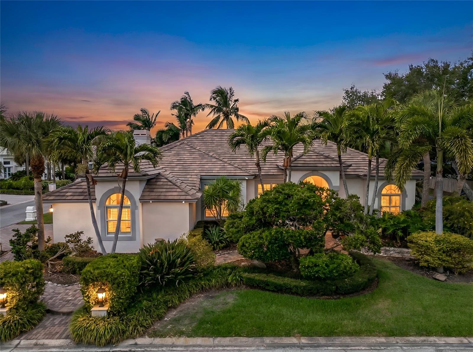Experience refined living in this exceptional single-level executive residence in the guard-gated community of Placido Bayou. Rarely available with this generous square footage and versatile floor plan, this Rutenberg-designed home offers the ideal combination of four bedrooms, a spacious bonus room, dedicated office, and a coveted three-car garage. Thoughtfully designed, the layout provides the perfect balance of open gathering spaces and private retreats, making it especially well-suited for multi-generational living, extended family, or owners with frequent guests.A custom-designed front landscape with dramatic evening illumination creates a striking first impression, while the side-entry three-car garage enhances the home's timeless curb appeal. Step inside to soaring ceilings and expansive living spaces where your eyes are immediately drawn through the home. One of this residence's most captivating features is the seamless connection to the outdoors, with peaceful views of the sparkling pool and cascading waterfall enjoyed from nearly every main living area—including the privately-situated primary suite. The ever-present backdrop of moving water and lush tropical surroundings creates an atmosphere that feels more like a private resort than a neighborhood home.The open-concept kitchen seamlessly connects to the inviting family room and showcases rich custom cabinetry, built-in features, and a warm gas fireplace framed by plantation-shuttered windows. Privately tucked away, the spacious primary suite offers a peaceful retreat where you can wake each morning to calming pool and waterfall views. The beautifully appointed ensuite features an updated walk-in shower, jetted soaking tub, dual sinks and an oversized customized walk-in closet. On the opposite wing of the home, three additional bedrooms and two full bathrooms provide exceptional privacy and flexibility.Step outside to your own private backyard oasis where an elevated screened lanai, soothing waterfall, and fully equipped outdoor kitchen set the stage for effortless Florida living. Whether hosting friends or enjoying a quiet evening, this outdoor retreat is designed to be enjoyed year-round. Additional highlights include a whole-house Generac generator, gas fireplace, gas tankless water heater, new zoned HVAC system with updated ductwork, stainless steel KitchenAid appliances, and a spacious laundry room with utility sink and extra space to air dry delicates.Ideally located just minutes from vibrant downtown St. Petersburg, you'll enjoy easy access to acclaimed dining, boutique shopping, the Vinoy Golf Club, Racquet Club tennis and pickleball facilities, beautiful Gulf beaches, Tampa, and two international airports. For added peace of mind, the home experienced no flooding during Hurricanes Helene or Milton.