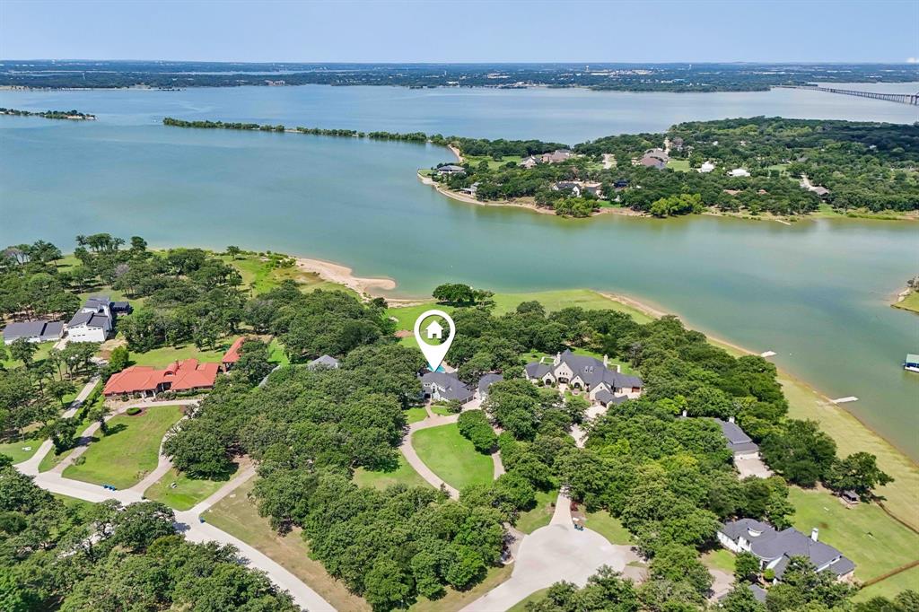 Experience one of the most extraordinary waterfront estates in DFW, offering 2.6 private acres with animpressive 266 feet of Lake Lewisville frontage. This rare property combines breathtaking sunset views,expansive open water, a calm cove, and unmatched convenience just minutes from PGA Headquarters,The Star, Legacy West, the Billion Dollar Mile, and DFW Airport. Designed for both relaxation andrecreation, the property features a sandy beach, ability to directly launch jet skis and boats, a portabledock for quick lake access. The lakeside bench swing from a large oak tree and a stunning 8-foot diameter fire pit are perfect for evenings by thewater. The flexible floor plan offers exceptional functionality with the primary suite and secondarybedroom located on the first floor, as well as two living rooms. Upstairs includes two additional bedrooms, a spacious game room, anda private office that can easily serve as a fifth bedroom. Outdoor living is truly resort-style, featuring asparkling pool, hot tub, covered patio, second-story balcony, and a tiki hut complete with a built-in grill,music speakers, and bar area ideal for entertaining family and friends year-round. Car enthusiasts andhobbyists will appreciate the 6-car detached garage (2023), offering abundant space for vehicles, laketoys, and equipment. Outdoor yard, landscape, and fruit trees watering done by lake pump. No watering restrictions. Recent home upgrades include Roof (2023), Exterior paint (2023), Pool Pebble Tecplaster (2022), updated bathrooms, and updated kitchen appliances. This one-of-a-kind lakefront retreatoffers luxury, privacy, recreation, and convenience all in one remarkable property. This Estate is a MustSee!