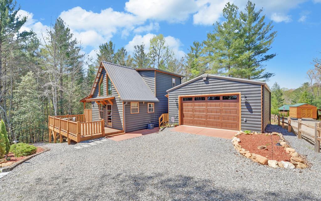 This 2-bed, 2-bath chalet-style retreat provides the mountain feel you want and the everyday function you need. From the great room with vaulted ceilings and a gas log fireplace to the walk-in pantry, and loft, this home offers the comfort and flexibility that make mountain living easy. Rich wood walls, ceilings, and floors add warmth and character throughout, while fiber optic internet gives you the freedom to work, stream, and stay connected without giving up the getaway feel. Outside, you'll find plenty of room to relax and entertain guests-motorcycling, fishing Lake Nottley, kayaking, and nature walks.  The side deck has been reinforced and is ready for your future hot tub, while the rear section of the wraparound deck is covered so you can enjoy the outdoors in more seasons. A low-maintenance yard gives you outdoor space without the constant upkeep. The fully insulated 24x30 oversized 2-car garage adds flexibility for storage, hobbies, and year-round vehicle protection, complete with pull-down stair access to an 8x24 storage loft. Additional home upgrades include a generator interlock system, metal roof, and zoned HVAC with separate thermostats for upstairs and downstairs. Several furniture items will also remain. All at a convenient base for enjoying Murphy's historic downtown, the River Walk, and Harrah's Cherokee Valley River Casino.