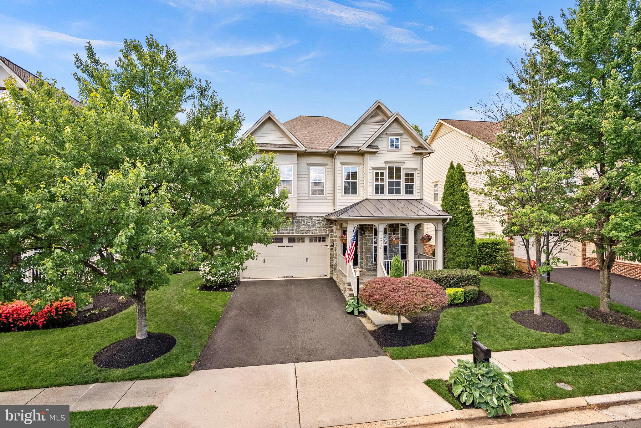 You’ll find 1920’s charm and character throughout this modern Miller & Smith Grand Clara Bow. Tucked away on a quiet Brambleton street, this more than 4,700 square foot home features an open floor plan with 10-foot ceilings, hardwoods on main level and large rooms throughout. Cozy front porch greets you. Step into the open entry space which can be used as a living room, dining room or combination of both. Large private office with French door is tucked away from the hustle and bustle. Kitchen features 42-inch maple cabinets (and there are plenty!), granite counters, cooktop (brand new one coming soon) and stainless appliances including a new double oven, and island with seating. A turret at the back of the home carries through all three levels and on this level serves as a charming and spacious space for a large kitchen table. Bar height seating is also available at the kitchen counter. Large family room adjacent from kitchen features floor-to-ceiling stone fireplace and built-in cabinetry. Step out to the deck where many wonderful spring, summer and fall evenings await the new owner! Home is situated in a very tranquil setting and backs to trees. Large Trex deck with automated shade and steps to beautiful patio and yard below. Back inside, take the hardwood stairs to the bedroom level. Hall and loft feature hardwood. This space is great for homework area, second office or upstairs living space. No disappointments in room sizes here. They are all HUGE! Primary bedroom has the same turret detail that makes for a perfect sitting area. The primary bathroom features oversized shower, soaking tub and large double vanity with a separate make-up area. Three other large bedrooms are on this level. Hall bath with double vanity has privacy door for toilet and tub/shower means multiple people can use this space at the same time. Step down to the fully-finished basement. And it’s a walk-out! So much space and natural light thanks to full-sized windows. This is sure to be a popular gathering spot with large British-pub inspired wet bar with stacked stone feature wall, kegerator and beverage fridge. This is the perfect space for pool, poker or just hanging out with the gang and watching a great game. Step out to large slate patio and this super gorgeous backyard! Homes comes complete with an exterior irrigation system so no need to worry about that beautifully landscaped yard. Car buffs will appreciate the extra-tall garage. Enjoy all Brambleton Community amenities - pools, parks, town center with shops, restaurants, gym, theater, Brambleton Library, Hanson Regional Park and Beaverdam Reservoir are a five-minute drive away. HOA fee includes upgraded Verizon FiOS internet and cable. Zoned for Legacy Elementary (walk zone), Brambleton & Watson Middle, Independence High School.