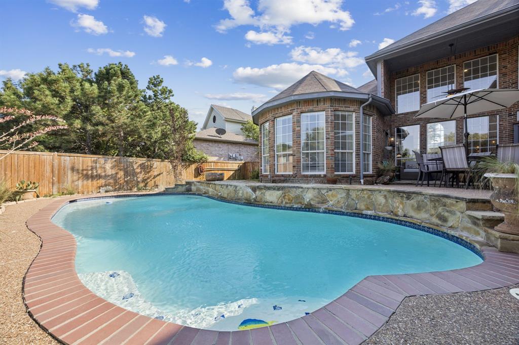 From the moment you step inside, you’ll fall in love with this spacious and thoughtfully designed 5 bedroom 4 bath home, featuring soaring ceilings, and an abundance of natural light. The open floor plan flows beautifully with wood floors throughout the entry, main living room, and chef’s kitchen. To the left of the entry is a versatile double room that provides endless possibilities to make this house truly feel like home, it's perfect as a formal living and dining space, dual offices, or a playroom. Two bedrooms and two full bathrooms are located downstairs, ideal for guests or multigenerational living. The oversized primary suite is tucked away at the back of the home with serene views of the pool and private backyard. Enjoy direct access to the patio, along with a spa-like bathroom with a huge walk-in shower, split vanities, and walk-in closet. The gourmet kitchen features stainless steel appliances, a downdraft cooktop vent in the island, a large stainless steel sink, and a pantry with space for all your Sam’s or Costco trips! The kitchen also includes a built-in desk or office nook that’s convenient for a home computer, managing household tasks, or helping with homework while dinner is on the stove. It opens effortlessly to the everyday dining area and expansive living room, featuring a stunning wall of windows and cozy fireplace. Upstairs, are three additional bedrooms; one with its own ensuite bath, while the other two share a full bathroom with dual sinks. A massive media or game room offers flexible space for movie nights, gaming, or gathering with loved ones. Outside is your own private oasis with a peaceful backyard that includes a sparkling pool, lush landscaping, and plenty of privacy for sunbathing, entertaining, or letting the kids swim in peace. There's even extra parking in the back for an RV, boat, trailer, or additional vehicles. This home truly has it all with space, function, luxury, and a location that puts you right in the heart of McKinney!